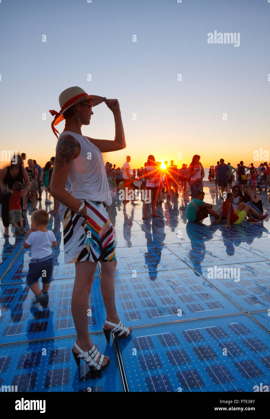Weibliche beobachten Sonnenuntergang in Zadar. Grüße an Sonne Denkmal. Stockfoto