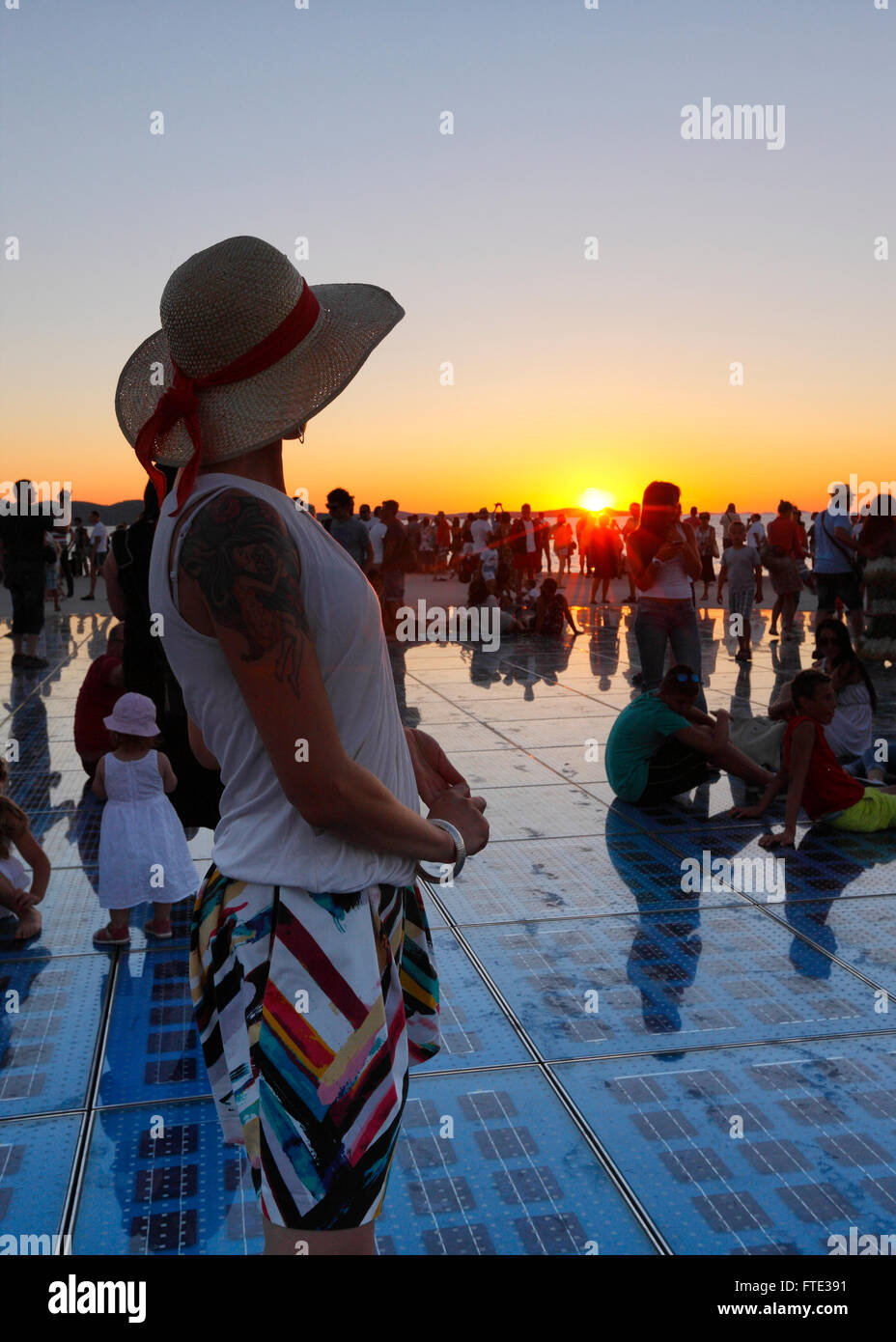 Weibliche beobachten Sonnenuntergang in Zadar. Denkmal - Grüße an Sonne. Stockfoto