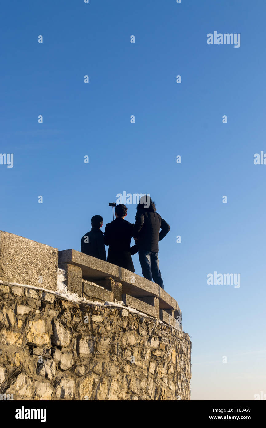 Gruppe von drei jungen Männer posieren für ein Bild mit einem Selfie-Stick. Die Isolation der Männer in der surrealen Umgebung fügt t Stockfoto