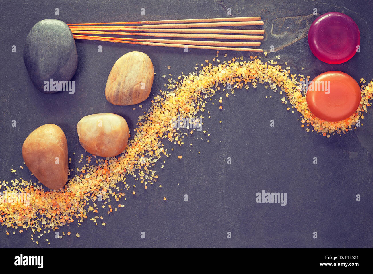 Vintage getönten Steinen auf Schiefer Hintergrund mit Räucherstäbchen und Seifen, Spa und Wellness Hintergrund. Stockfoto