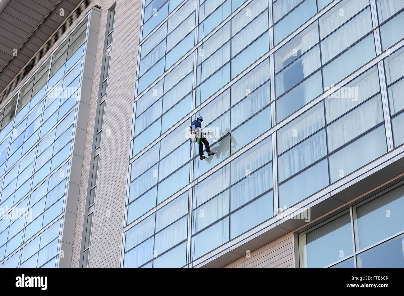 Abseilen-Fensterreiniger, reinigen Sie die Fenster an der Lowry Hotel Manchester Stockfoto