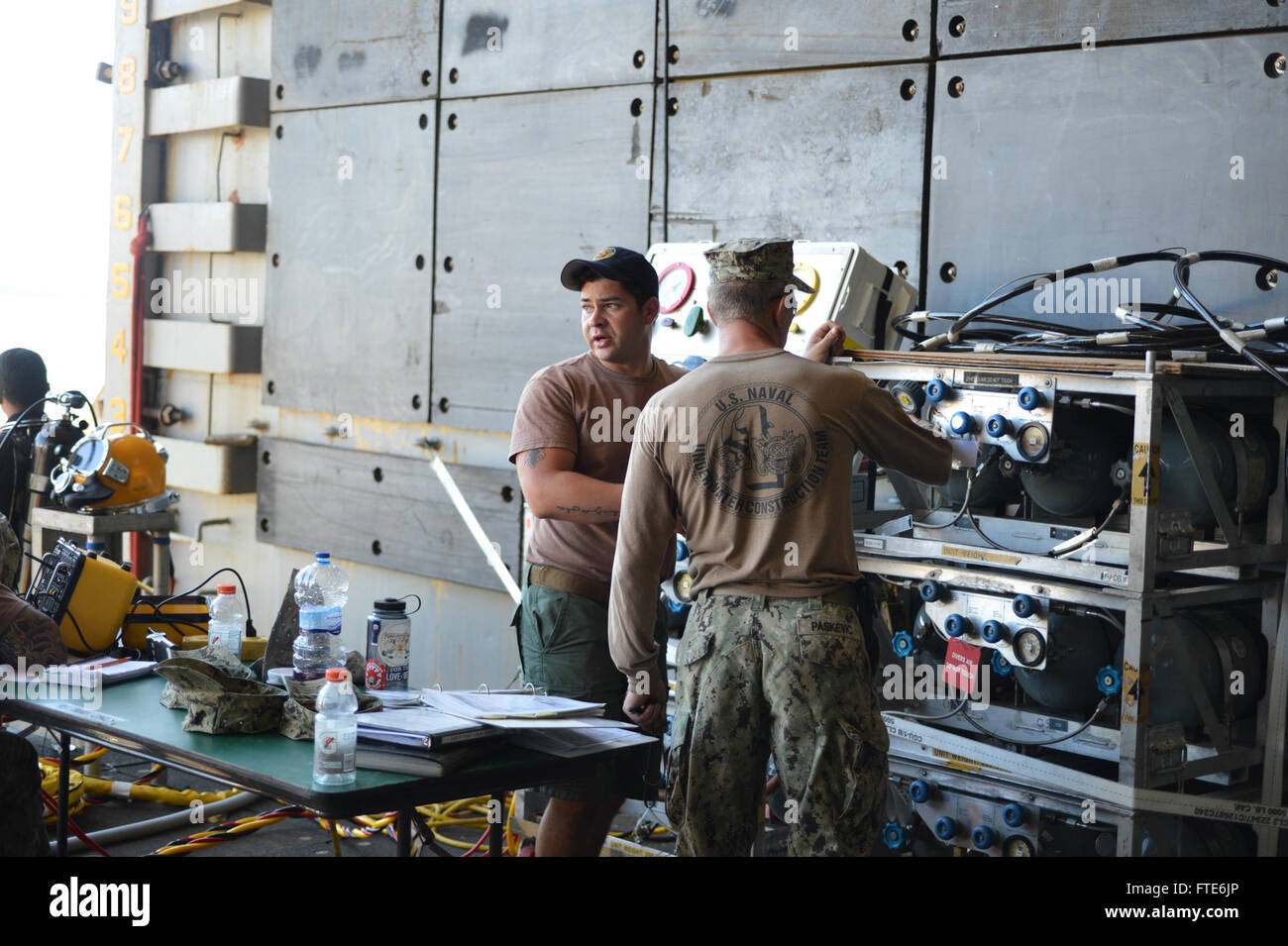 Die Seeleute von Sprengstoffverordnungs-Mobile Einheit 8 und U.S. Naval Underwater Construction Team 1 führen Tauchoperationen an Bord der USS Oak Hill (LSD 51) in der Marinestation Rota, Spanien durch. Die Aufgabe konzentriert sich auf die Entfoulung der Fahrausrüstung des Schiffes, um seine Einsatzbereitschaft zu erhalten. Stockfoto