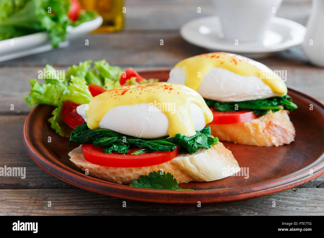 Pochierte Eggs Benedict mit Spinat und Tomaten Stockfoto