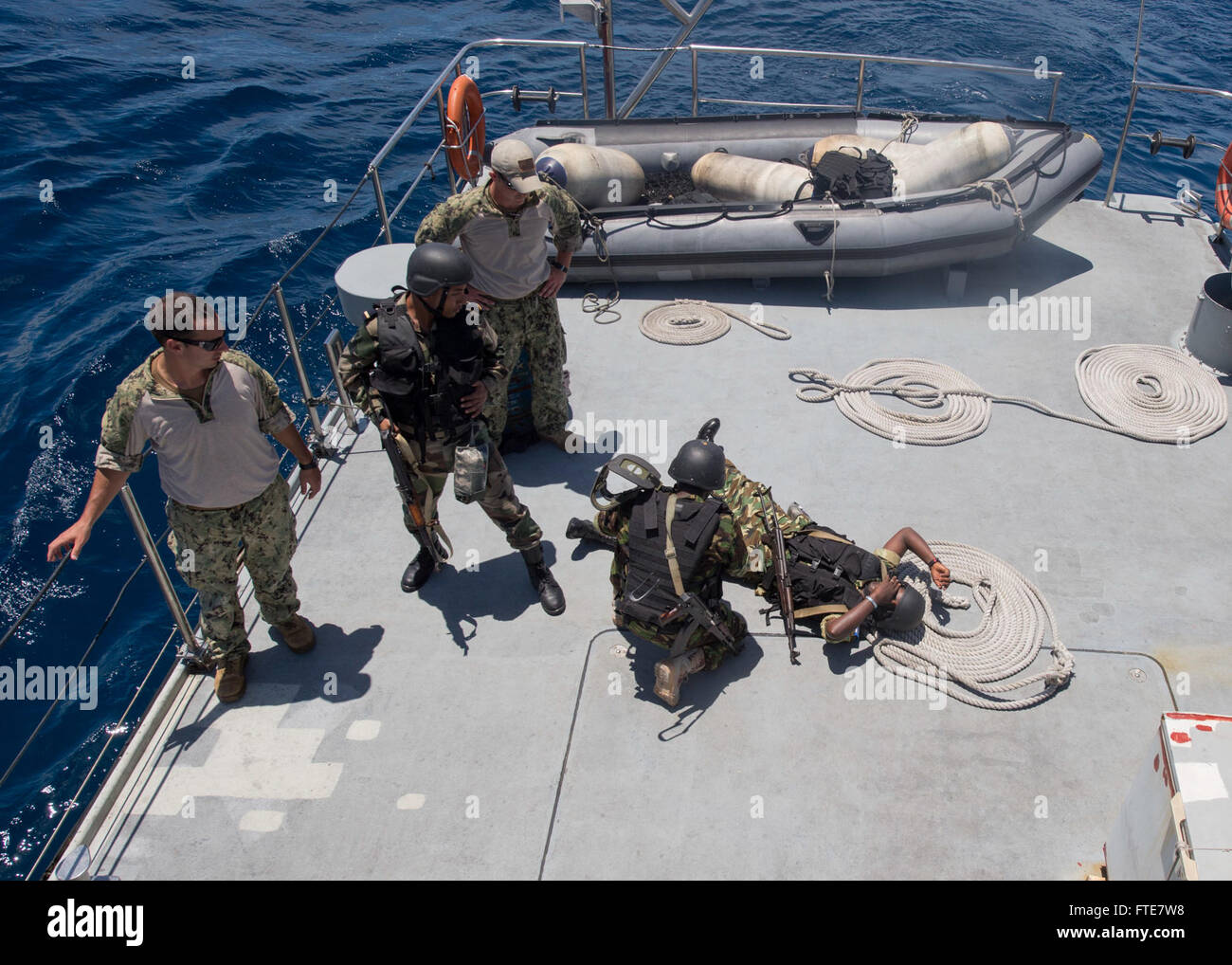 Während der Cutlass Express 2013-Übung vor der Küste der Seychellen leistet ein Mitglied der Ostafrikanischen Bereitschaftstruppe erste Hilfe für einen simulierten Unfall, wie Experten der US Navy beobachten. Ziel der Maßnahme war es, die maritime Zusammenarbeit und die taktischen Operationen zwischen ostafrikanischen Ländern zu verbessern. Stockfoto