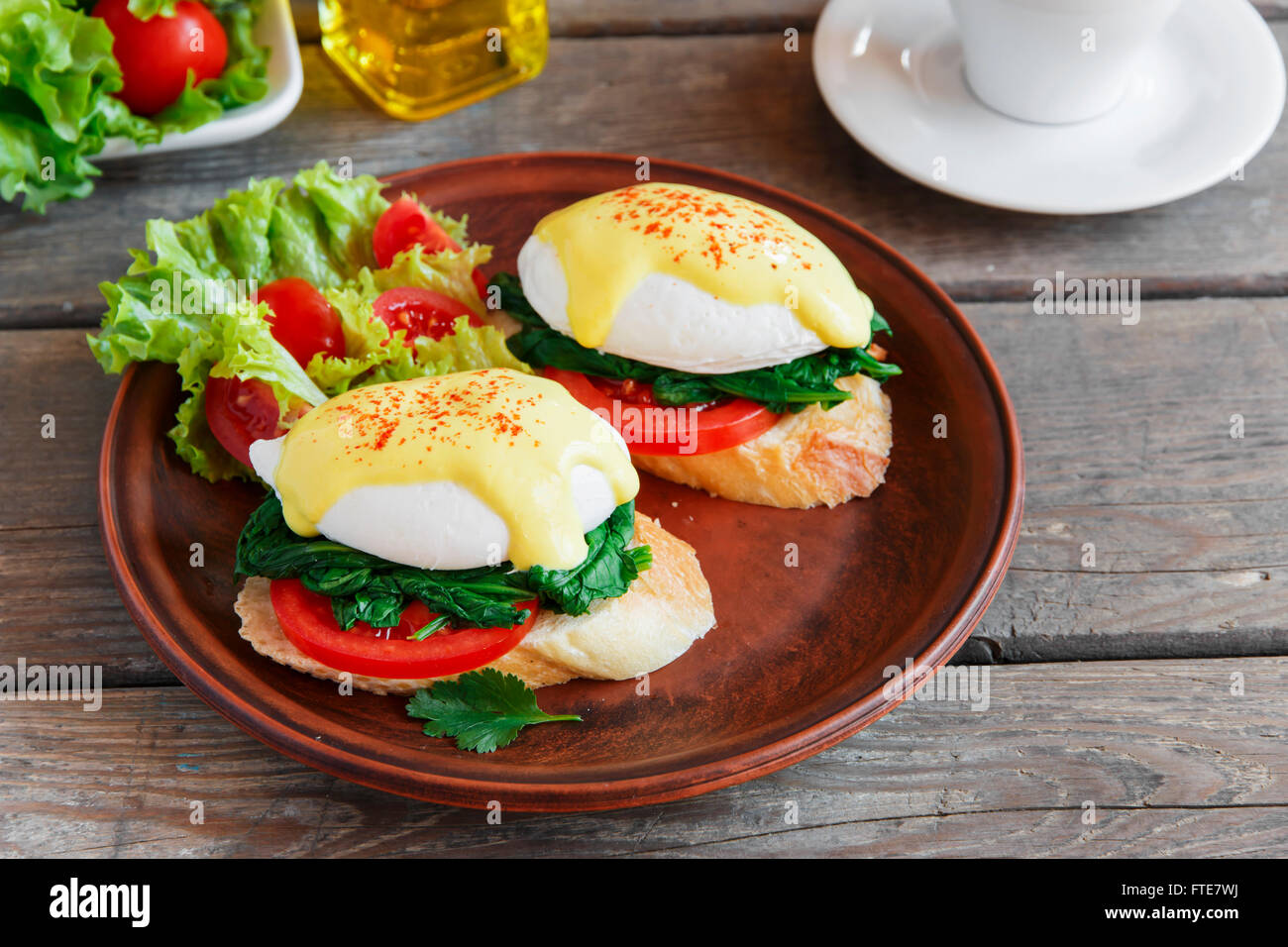 Pochierte Eggs Benedict mit Spinat und Tomaten Stockfoto