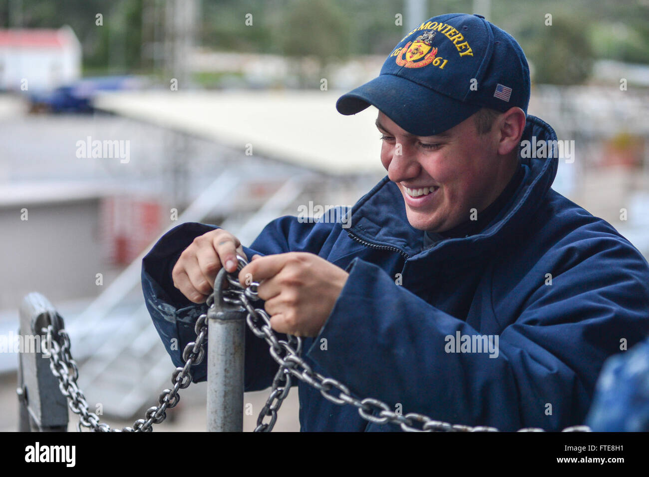 Am 13. Dezember 2013 bringt Seaman Recruit Cody Smith von der USS Monterey (CG 61) Handläufe an Bord des Schiffes an, da es in der Souda Bay, Griechenland, für einen geplanten Hafenbesuch während seines Einsatzes in der 6. US-Flotte vertäut wird. Stockfoto