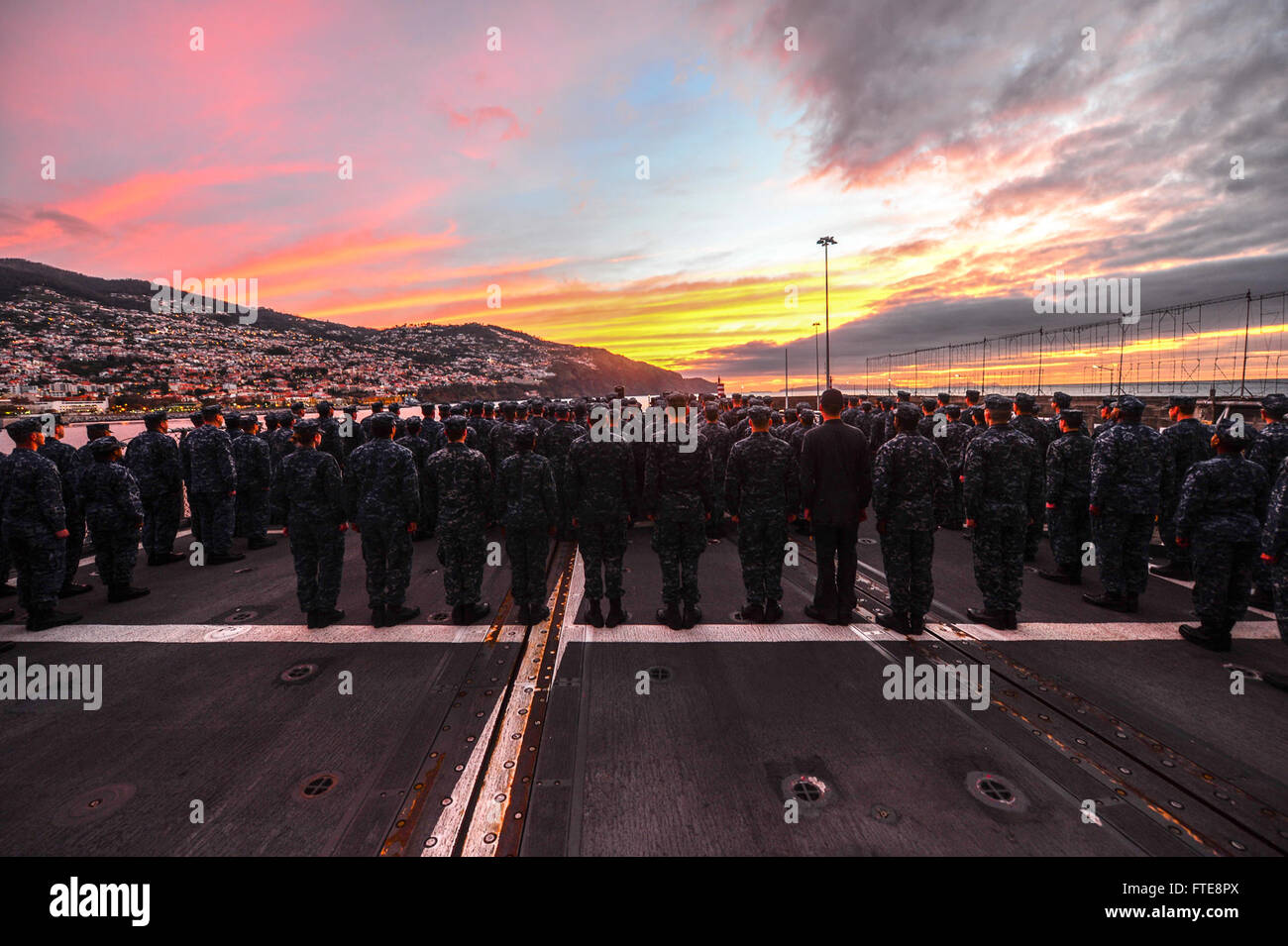 Am 24. Dezember 2013 standen die Seeleute an Bord der USS Monterey (CG 61) für die Morgenfarben auf dem Andocken des Schiffes in Funchal (Portugal). Das Schiff war Teil der fortlaufenden maritimen Sicherheitsoperationen und der Zusammenarbeit im Bereich der Theatersicherheit im Gebiet der 6. US-Flotte. Stockfoto