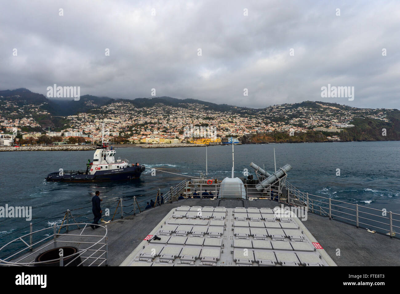 Die USS *Monterey* (CG 61) wird von einem Schlepper unterstützt, als sie am 26. Dezember 2013 in Funchal (Portugal) verlässt. Der Lenkraketenkreuzer wird zur Unterstützung der maritimen Sicherheit und der internationalen Zusammenarbeit im Einsatzgebiet der 6. US-Flotte eingesetzt. Stockfoto