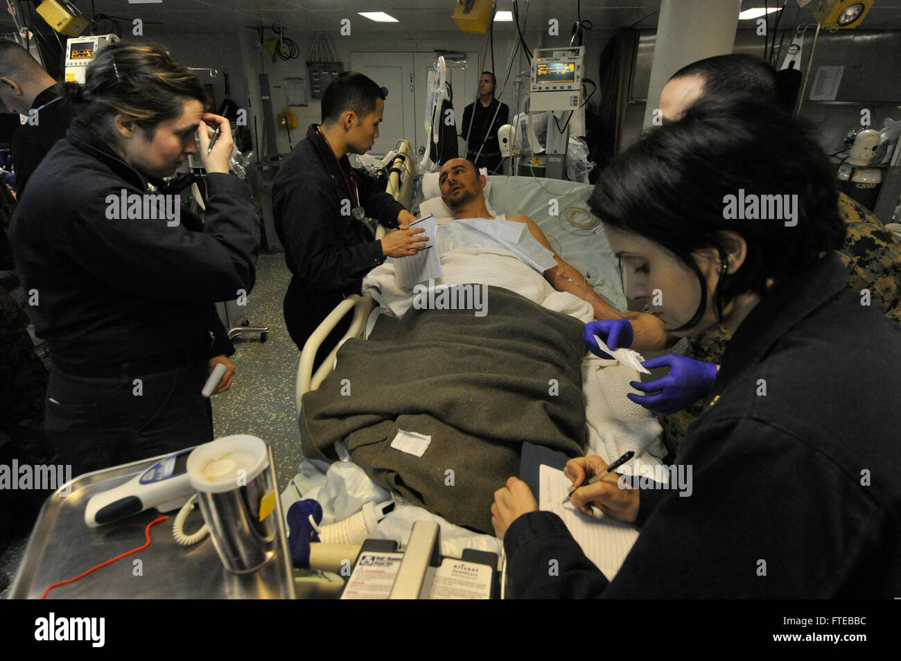 Die USS *Bataan* (LHD 5), ein amphibisches Angriffsschiff, führt eine Such- und Rettungsaktion in der Ägäis durch. Seeleute in der medizinischen Abteilung unterstützen einen türkischen Seefahrer und heben die Rolle des Schiffes bei der maritimen Sicherheit und humanitären Missionen hervor. Stockfoto