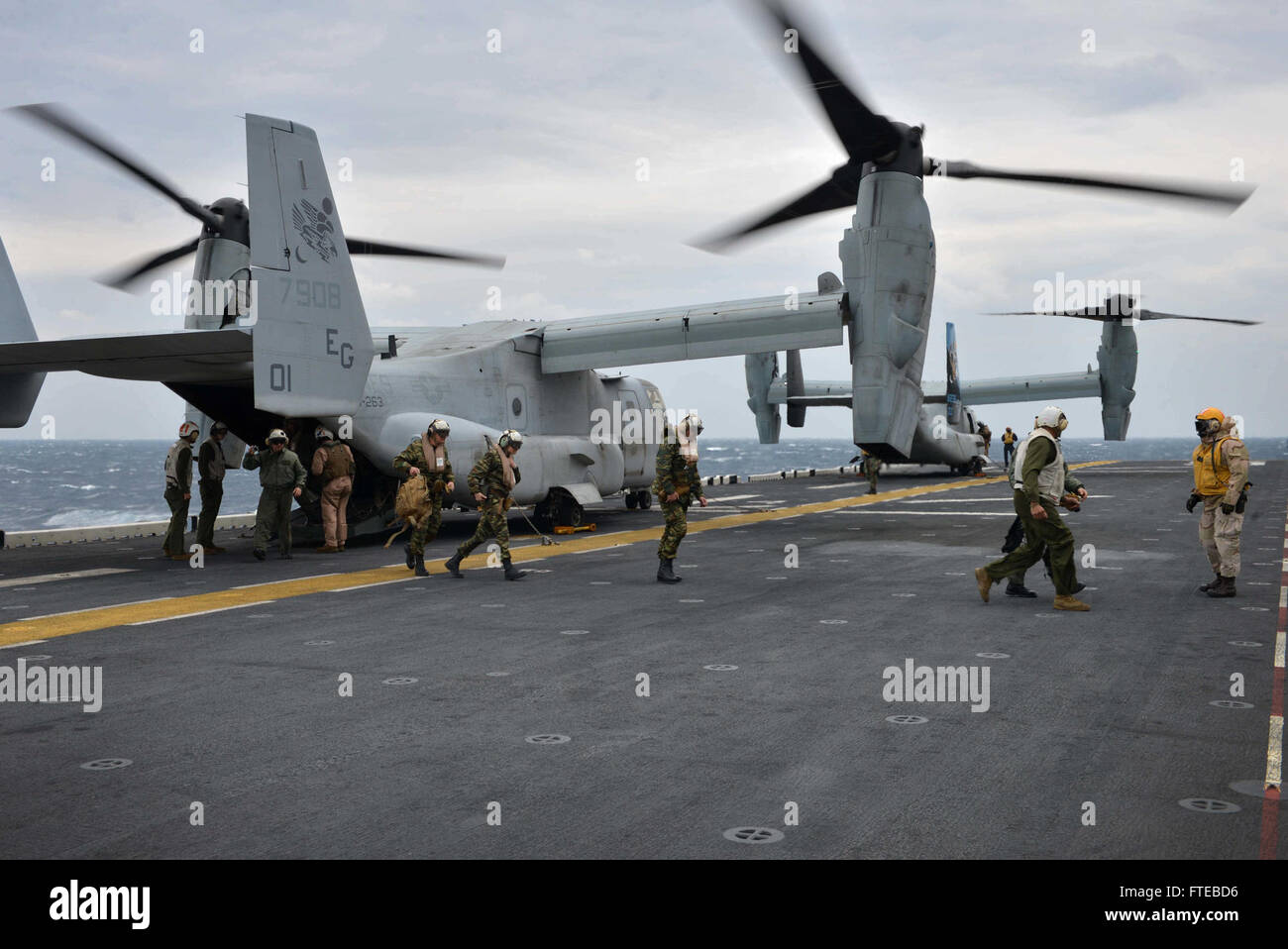 140309-N-HO612-023: Ägäis (9. März 2014) - Mitglieder der griechischen Streitkräfte Aussteigen aus einem MV-22 Osprey auf dem Flugdeck der Mehrzweck amphibischer Angriff Schiff USS Bataan (LHD-5). Die Bataan amphibische Bereitschaft Gruppe ist auf eine geplante Bereitstellung unterstützen maritimer Sicherheitsoperationen Absicherung Krise Antwort Fähigkeit und Theater Kooperationen in den USA 6. Flotte Einsatzgebiet. (U.S. Navy Photo by Massenkommunikation Spezialist 3. Klasse Erik Foster / veröffentlicht) Stockfoto