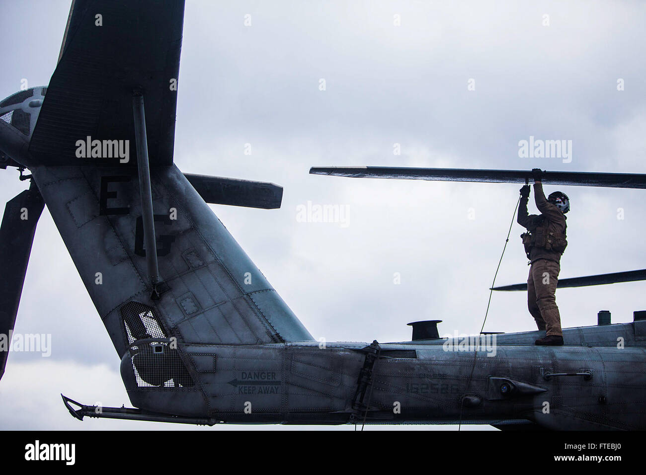 Sgt. Cody Pensabene, Mitglied der Marine Medium Tiltrotor Squadron (VMM) 263, befestigt Kabel an den Klingen eines CH-53E Super Hallion Hubschraubers an Bord der USS Bataan (LHD 5) nach einer bilateralen Übung mit der Hellenischen Armee. Die Übung zielte darauf ab, die militärischen Beziehungen zwischen den USA und Griechenland zu stärken und fand im März 2014 in der Ägäis statt. Stockfoto Sgt. Cody Pensabene, Mitglied der Marine Medium Tiltrotor Squadron (VMM) 263, befestigt Kabel an den Klingen eines CH-53E Super Hallion Hubschraubers an Bord der USS Bataan (LHD 5) nach einer bilateralen Übung mit der Hellenischen Armee. Die Übung zielte darauf ab, die militärischen Beziehungen zwischen den USA und Griechenland zu stärken und fand im März 2014 in der Ägäis statt. Stockfoto