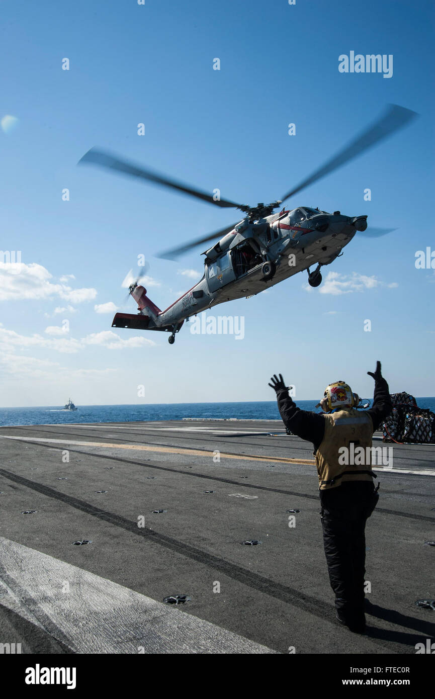 140314-N-SI489-026 Mittelmeer (14. März 2014) Luftfahrt Boatswain Mate (Handling) 2. Klasse Toro Melendez aus Bayamon, Puerto Rico, leitet eine MH-60R Seahawk, befestigt an der "Dreizack" der Hubschrauber Meer bekämpfen Squadron (HSC) 9, während eine vertikale Nachschub an Bord des Flugzeugträgers USS George H.W. Bush (CVN-77). George H. W. Bush ist auf eine geplante Bereitstellung unterstützen maritimer Sicherheitsoperationen und Sicherheitsbemühungen Zusammenarbeit Theater in den USA 6. Flotte Einsatzgebiet. (Foto: U.S. Navy Masse Kommunikation Spezialist Seemann Andrew Johnson/freigegeben) Stockfoto