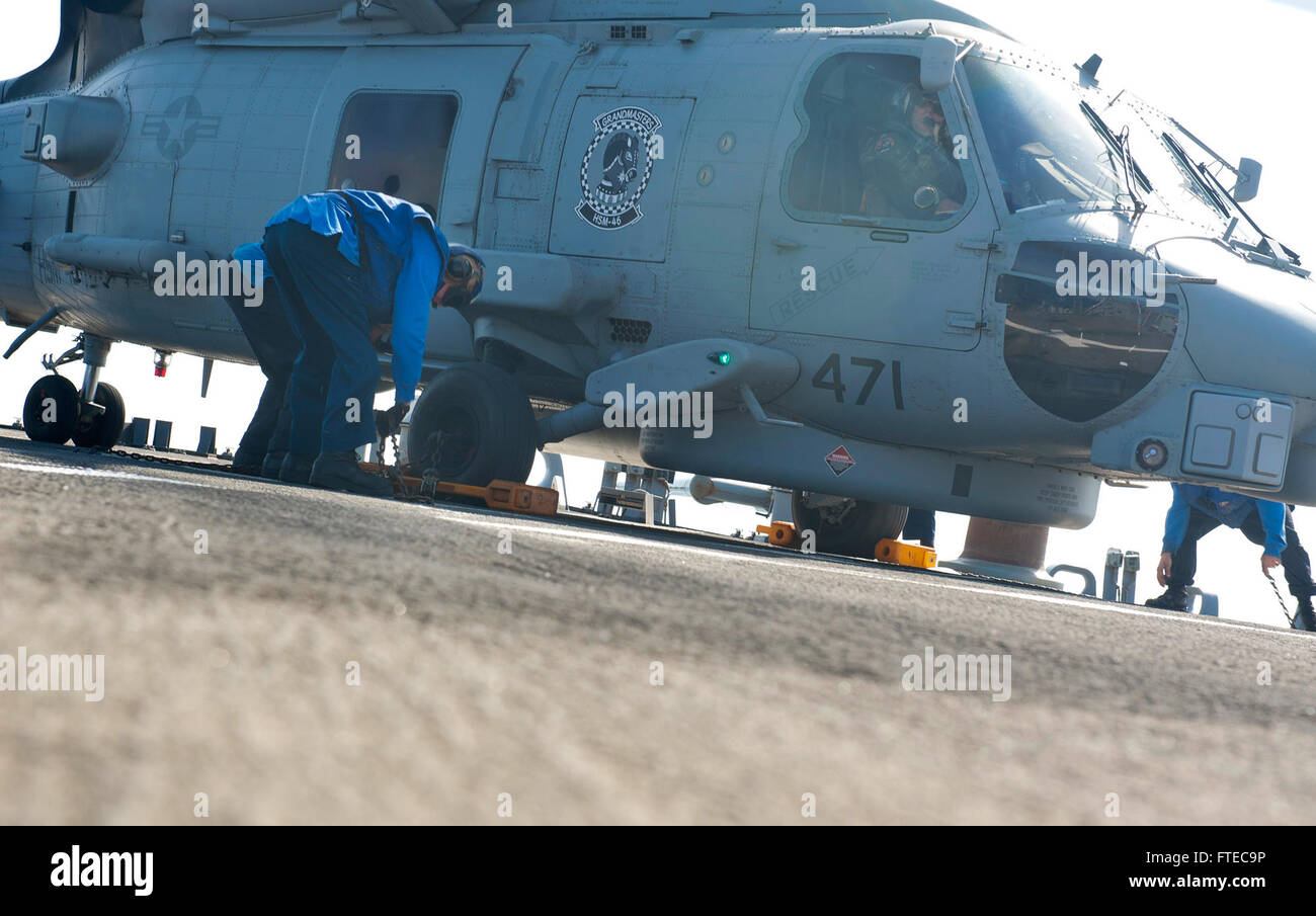 140317-N-WD757-198 Mittelmeer (17. März 2014) – schließen Sie Segler Unterlegkeil und Ketten an einen MH-60R Sea Hawk Hubschrauber zugewiesen, der Großmeister der Hubschrauber Maritime Squadron (HSM) 46 auf dem Flugdeck der geführte Flugkörper-Zerstörer USS Arleigh Burke (DDG-51). Arleigh Burke ist auf eine geplante Bereitstellung zur Unterstützung der Sicherheit im Seeverkehr Operationen und Sicherheitsbemühungen Zusammenarbeit Theater in den USA 6. Flotte Einsatzgebiet. (Foto: U.S. Navy Mass Communication Specialist 2. Klasse Carlos M. Vazquez II/freigegeben)  Nehmen Sie das Gespräch auf Twitter (https://twitter.com/naveur navaf Stockfoto