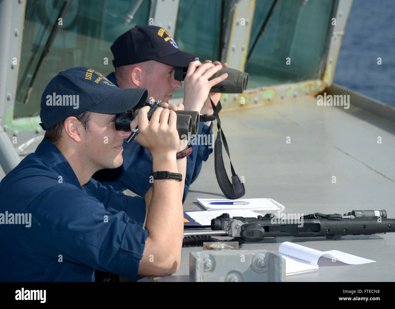 Das Bild zeigt Fähnrich Jonathan Hill und Chief Operations Specialist Jonathan Edington von der USS Ramage, die am 25. März 2014 Anti-Terror-Training absolvierten. Das Training fand auf dem Brückenflügel während eines simulierten Angriffs auf kleine Boote statt. Die USS Ramage, ein Teil der 6. Flotte der US Navy, unterstützte während ihres Einsatzes die maritimen Sicherheitsoperationen und die Zusammenarbeit im Bereich der Theatersicherheit. Stockfoto