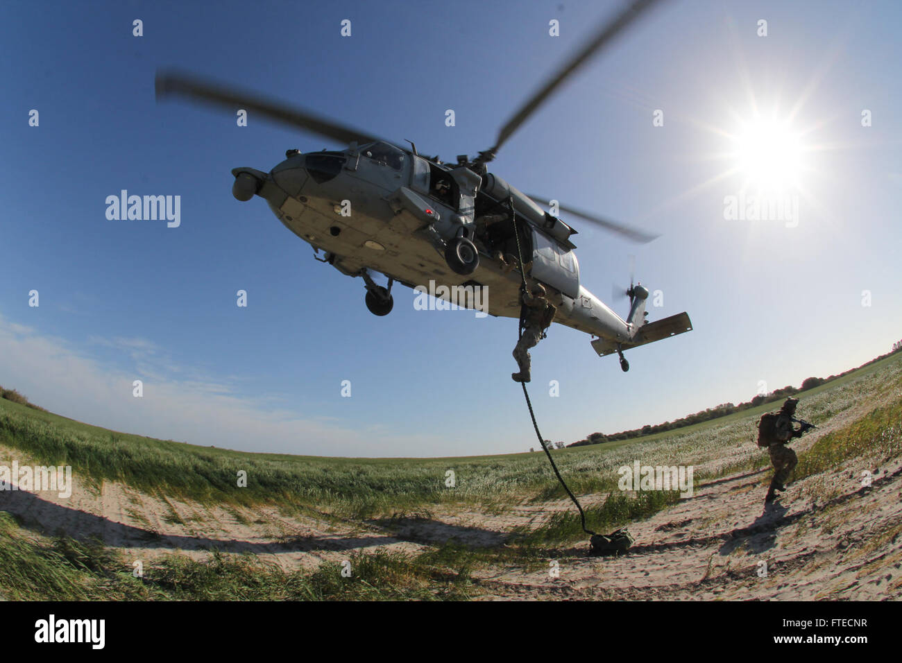 Dieses Bild zeigt eine Militäroperation in Rota, Spanien, bei der Mitglieder der mobilen Einheit zur Entsorgung von Sprengstoffen (EODMU) 8 schnelle Seiloperationen mit den Ghostridern der Helicopter Sea Combat Squadron (HSC) 28 durchführen. Das Foto zeigt moderne militärische Taktiken und Flugoperationen. Stockfoto