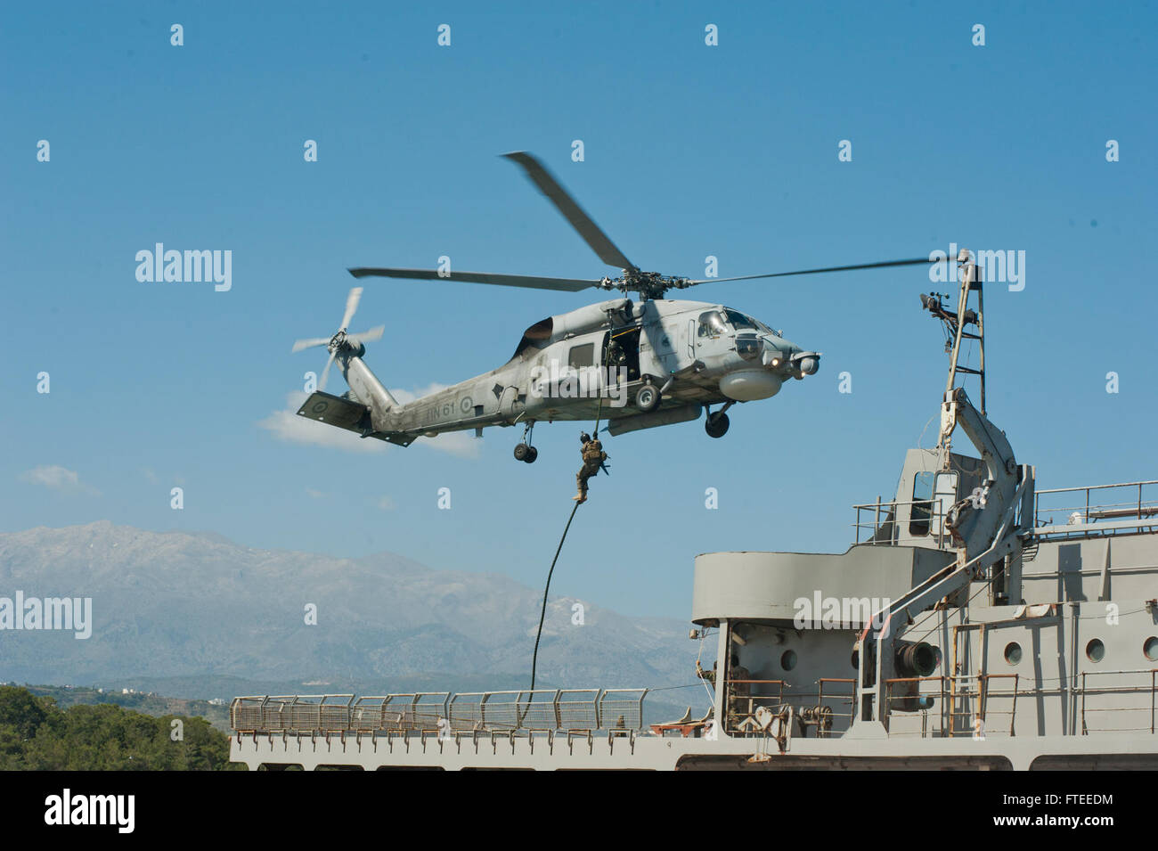 Dieses Foto zeigt ein Mitglied des algerischen Boarding-Teams, das während der Übung Phoenix Express 2014, einer multinationalen maritimen Sicherheitsübung im Mittelmeer, von einem griechischen Hubschrauber auf das Schiff „Aris“ der NATO Maritime Interdiction Operational Training Center (NMIOTC) schnappt. Stockfoto