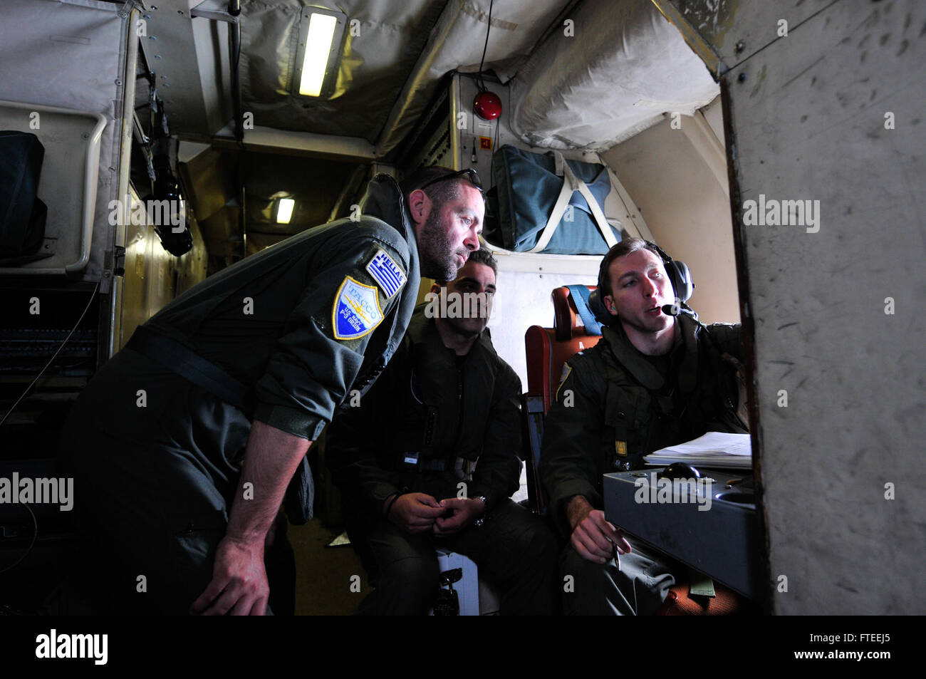 Während Der Übung Phoenix Express 2014, Lt. Commander. Christos Adrianoupolitis und Lt. Commander. Christos Kontos von der Hellenic Air Force 353 Maritime Patrol Squadron beobachtet Lt. j.g. Mark Knorr von der US Navy Patrol Squadron 9. Durch die Förderung der internationalen Zusammenarbeit zwischen den teilnehmenden Nationen wird die Sicherheit des Mittelmeerraums verbessert. Stockfoto