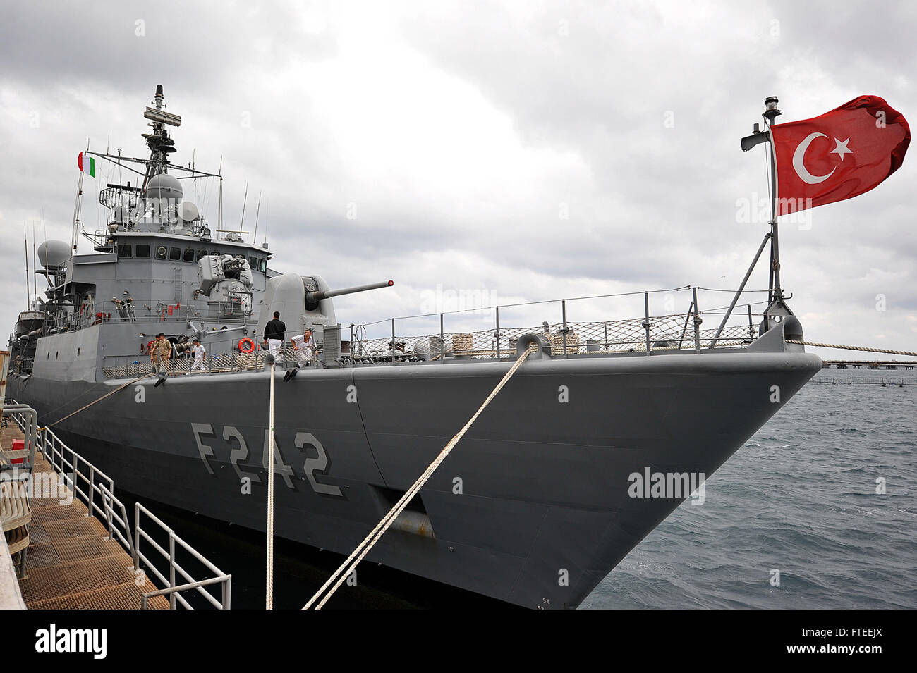 Die türkische Fregatte TCG Fatih (F-242) kommt während des Phoenix Express 2014 in Augusta Bay auf Sizilien an. Türkische Seeleute werden im Rahmen der multinationalen Übung, die sich auf die Verbesserung der Sicherheit im Seeverkehr im Mittelmeerraum konzentriert, mit dem Festmacherangeln gesehen. Stockfoto