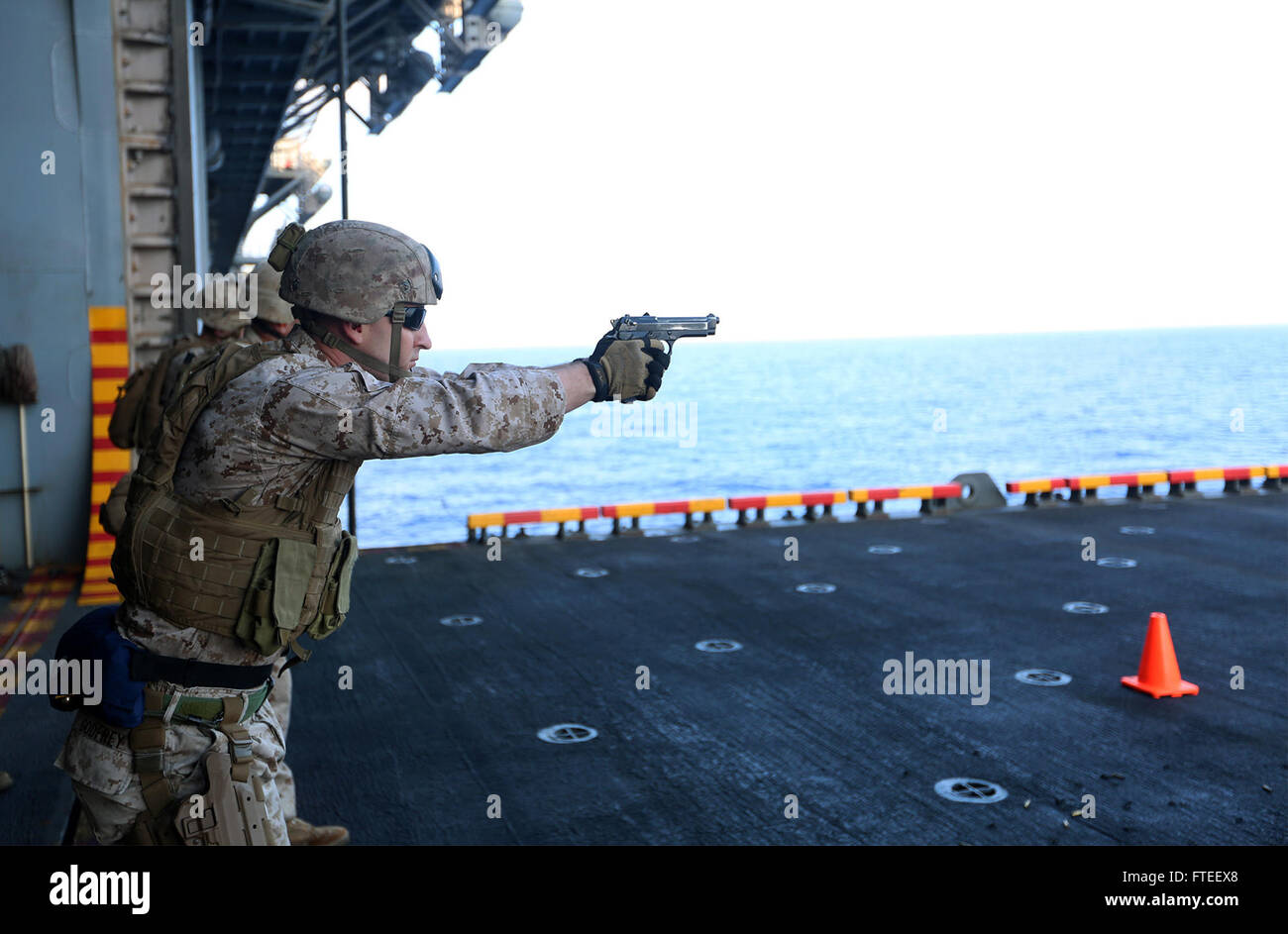 Ein US-Marine vom Battalion Landing Team 1st Battalion, 6th Marine Regiment, 22nd Marine Expeditionary Unit (MEU) übt aus, seine M-9-Dienstpistole an Bord der USS Bataan (LHD 5) während einer Feuerübung am 10. Juni 2014 abzufeuern. Dieses Foto zeigt die Intensität der US-Militärausbildung auf See im Gebiet der 6. US-Flotte. Stockfoto
