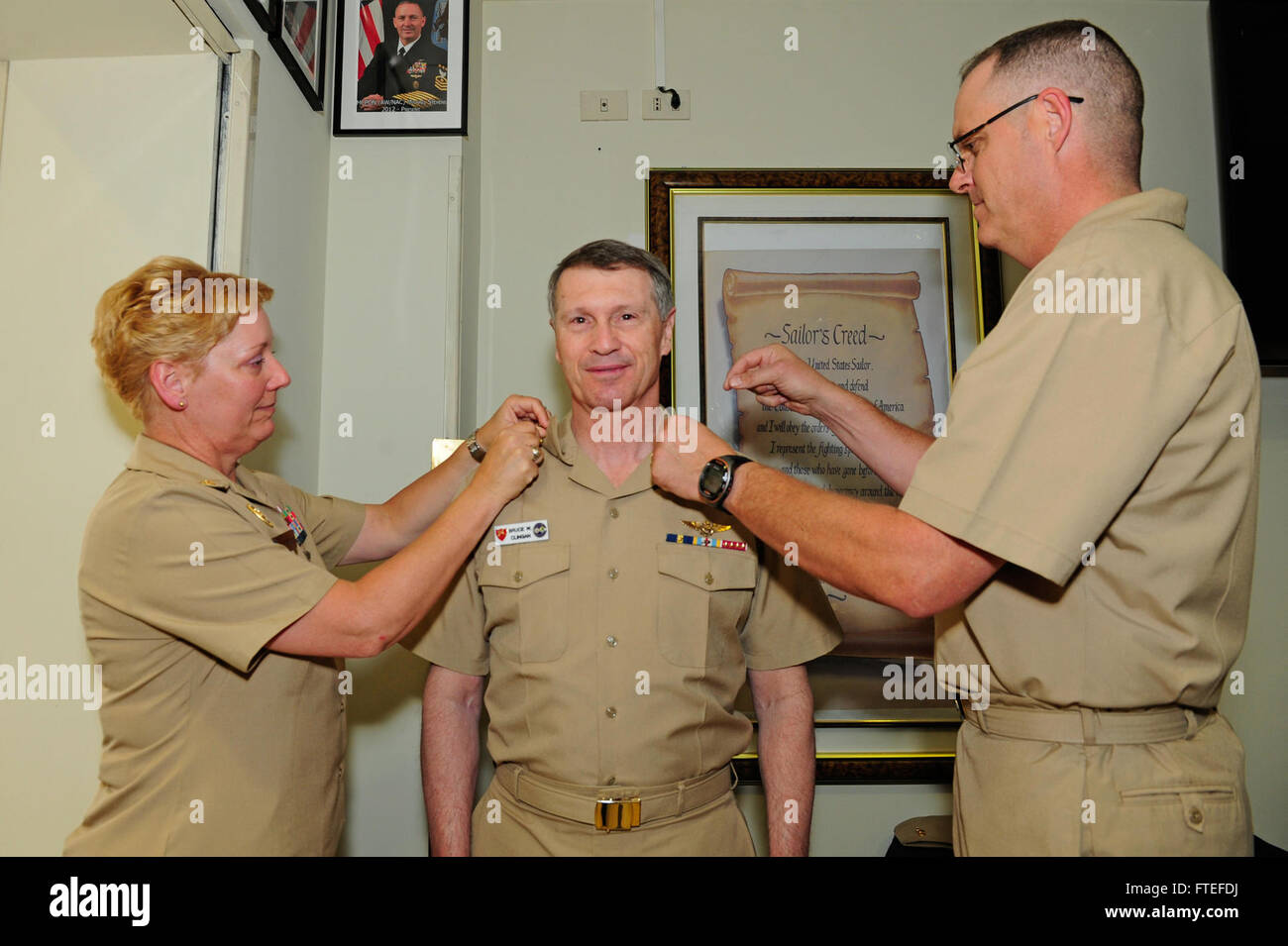 Neapel, Italien (14. Juli 2014) Commander, US Naval Forces Europe-Africa, Admiral Bruce W. Clingan, erhält Häuptlings Anker von U.S. Naval Forces Europe-Africa Fleet Master Chief JoAnn Ortloff, links, und US 6. Flotte Command Master Chief Charles "Chip" Collins in Neapel Bereich Chief Petty Officers durcheinander. Clingan benannt ein honorary Chief Petty Officer für seine Unterstützung Chiefs während seiner Zeit als Commander, US Naval Forces Europe-Africa und im Laufe seiner Karriere. Stockfoto