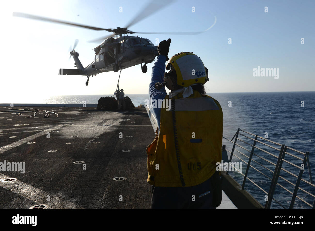 Am 3. Oktober 2014 signalisiert Aviation Boatswain’s Mate 3rd Class Kimberly Toro einen UH-1 Huey Hubschrauber an Bord der USS Mesa Verde (LPD 19) während einer vertikalen Auffülloperation auf See. Die Operation unterstützt die Marineoperationen im Gebiet der 6. US-Flotte. Stockfoto