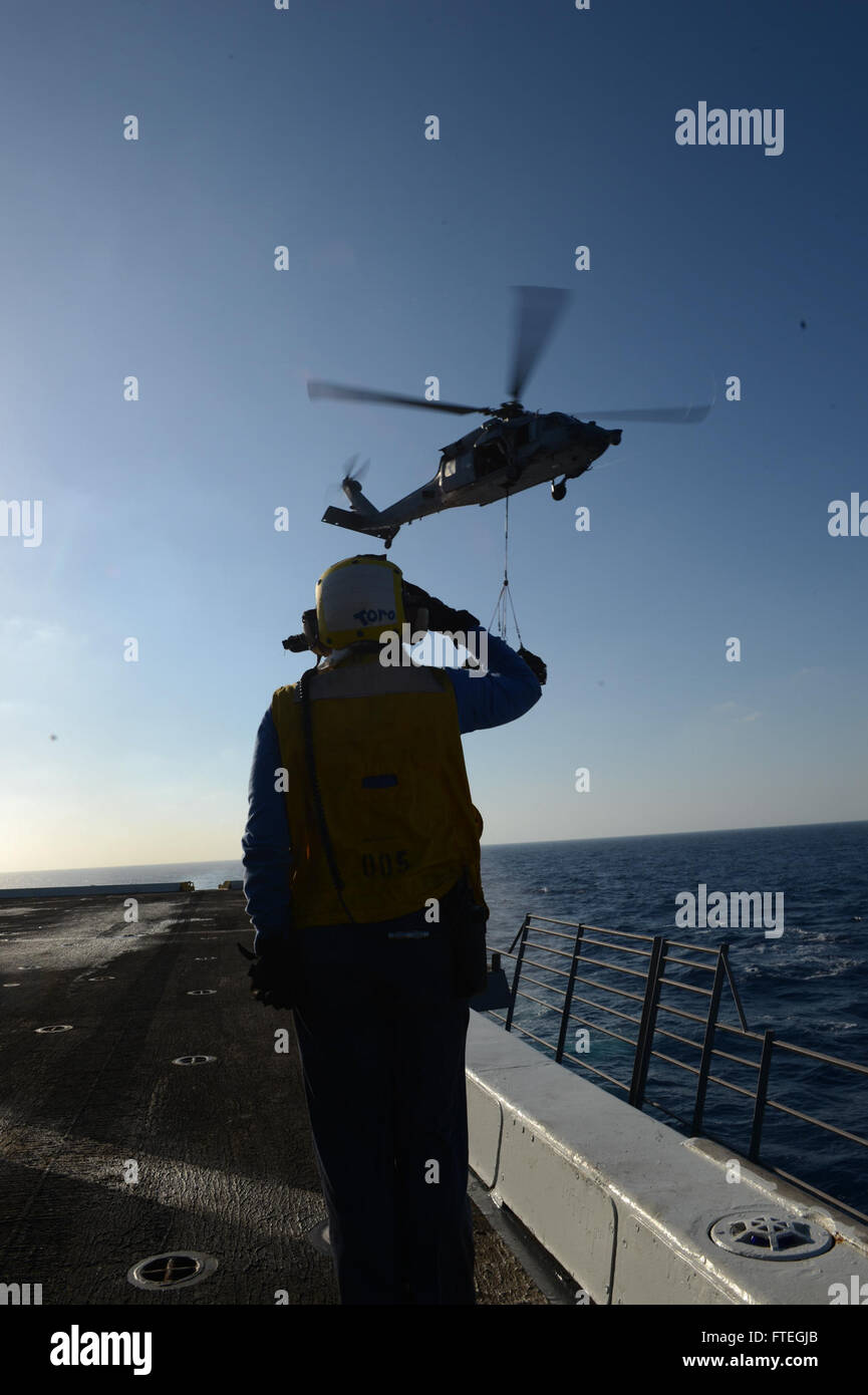 Aviation Boatswain's Mate (Handling) 3rd Class Kimberly Toro grüßt einen UH-1 Huey auf dem Flugdeck der USS Mesa Verde (LPD 19) im Rahmen einer vertikalen Replenishment-at-Sea-Operation mit der USNS Leroy Grumman (T-AO 195) im Mittelmeer am 3. Oktober 2014. Die USS Mesa Verde wird zur Unterstützung der US-Militäroperationen in der Region eingesetzt. Stockfoto