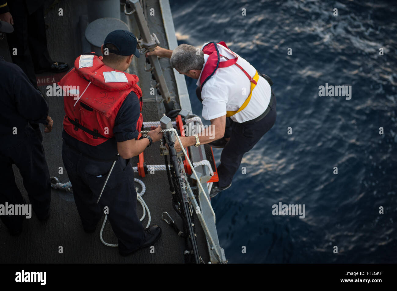 IBIZA, Spanien (4. Oktober 2014) An Ibiza Hafen Pilot klettert eine Leiter an Bord die Arleigh Burke-Klasse, geführte Flugkörper Zerstörer USS Mitscher (DDG-57) bevor das Schiff im zieht Hafen besuchen. Hafen-Piloten Leitfaden der Besatzung das Schiff in Häfen mit anspruchsvollen Manövern oder bei schlechtem Wetter. Mitscher, in Norfolk, Virginia, Gridley führt Marinebetriebe in den USA 6. Flotte Bereich der Maßnahmen zur Erhöhung der Sicherheit der Vereinigten Staaten in Europa interessiert. Stockfoto