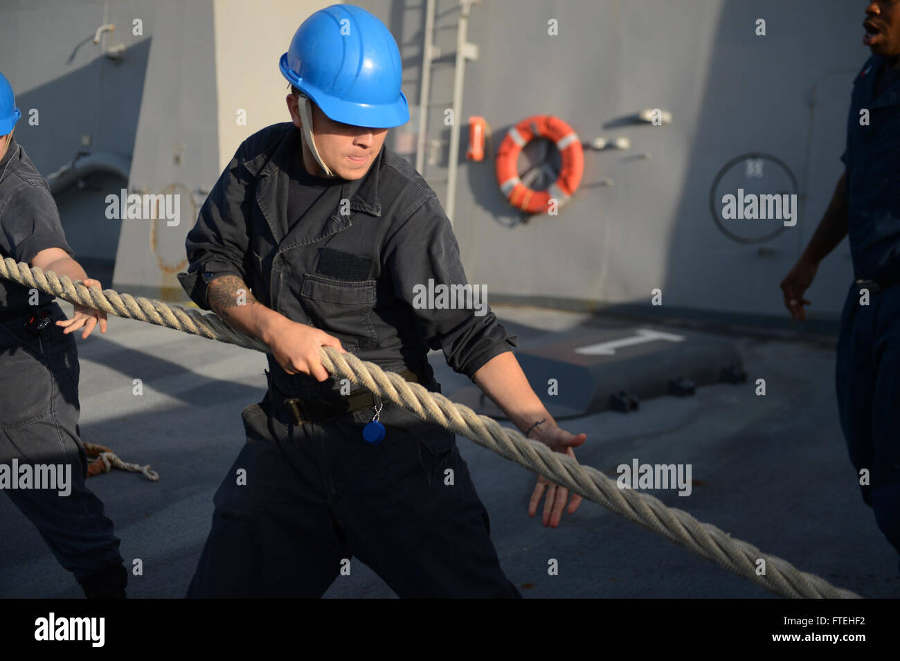 Am 15. Oktober 2014 führt Aviation Boatswain's Mate Airman Mykael Blanco aus Hialeah, Florida, einen Liniensprung an Bord der USS Mesa Verde (LPD 19) durch, als sie in Rota, Spanien, ankommt. Das Amphibien-Transportdock ist Teil der Bataan Amphibious Ready Group, die zur Unterstützung der nationalen Sicherheitsinteressen der USA in Europa tätig ist. Stockfoto