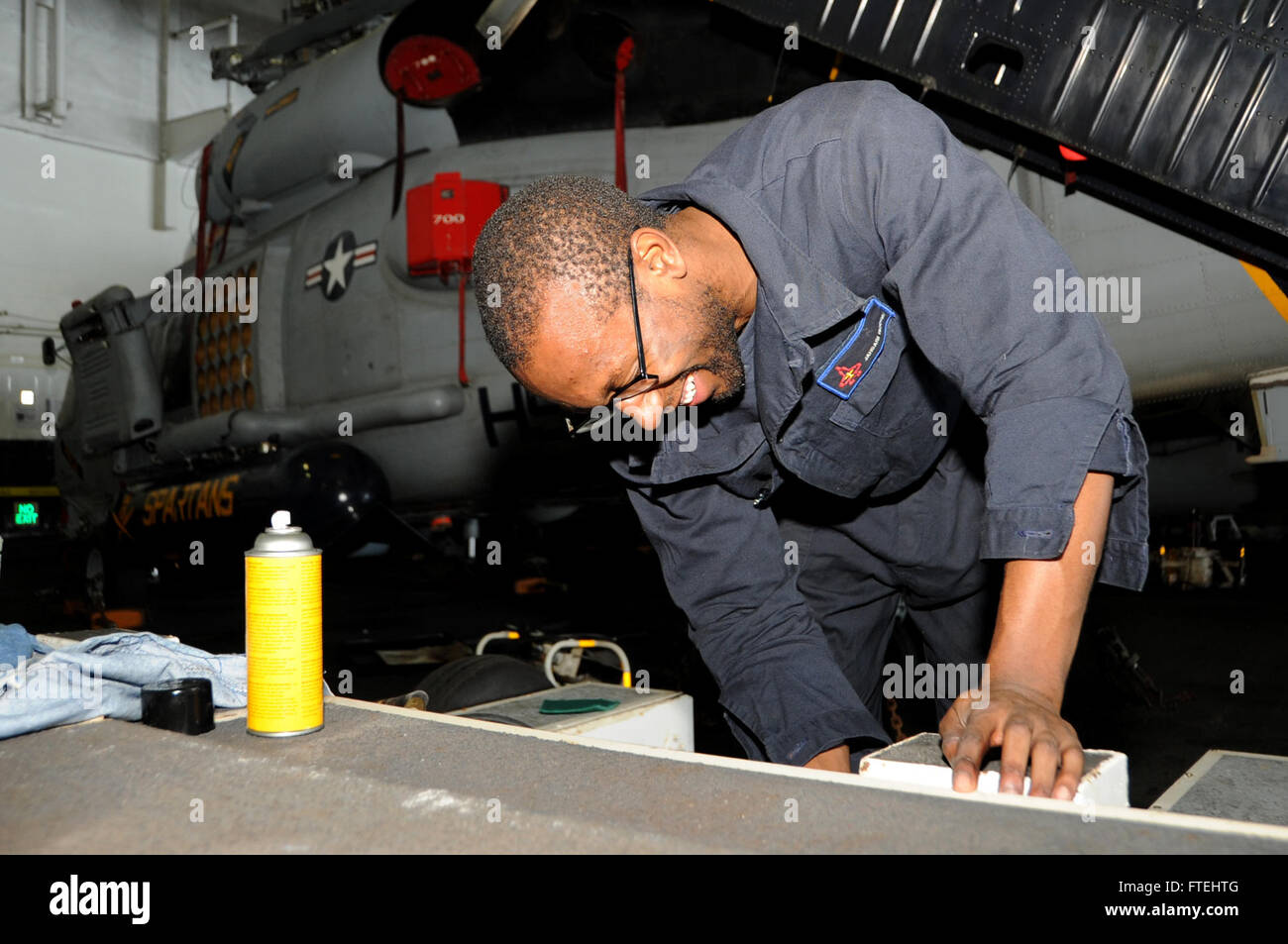 Das Bild zeigt den Aviation Support Equipment Technician Jahbari Hodge, der einen Dolly an Bord der USS George H.W. Bush (CVN 77) während des Einsatzes im Mittelmeer reinigt. Dieses Schiff unterstützt die militärischen Bemühungen der USA in der Region. Stockfoto