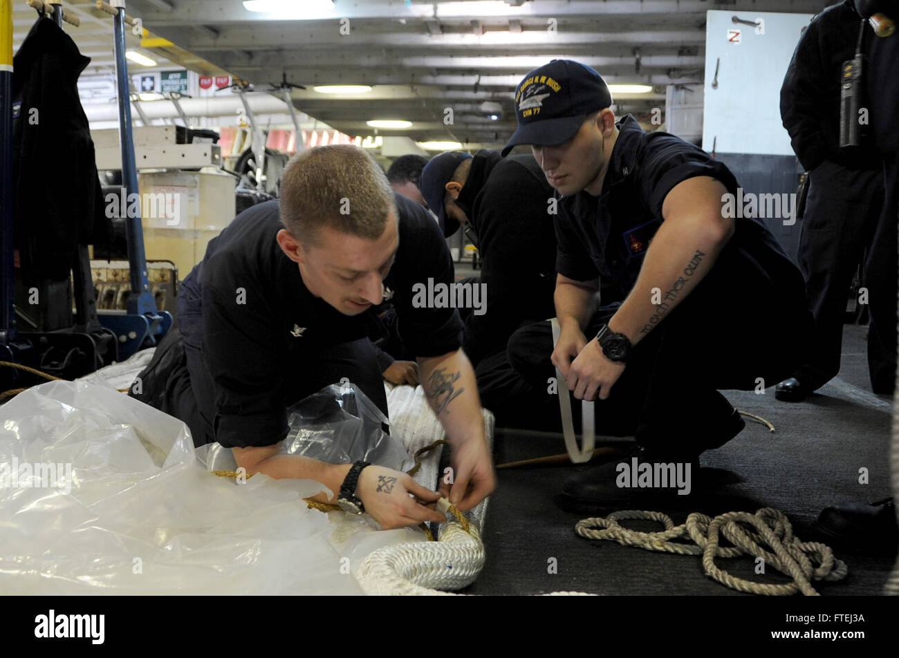Boatswain's Mate Seaman Joe Etter und Boatswain's Mate 3rd Class Alexander Ames arbeiten zusammen, um eine Liegelinie an Bord der USS George H.W. Bush (CVN 77) zu spleißen. Dieser Flugzeugträger, der in Norfolk, VA, stationiert ist, operiert im Gebiet der 6. US-Flotte und unterstützt nationale Sicherheitsinteressen in Europa. Stockfoto
