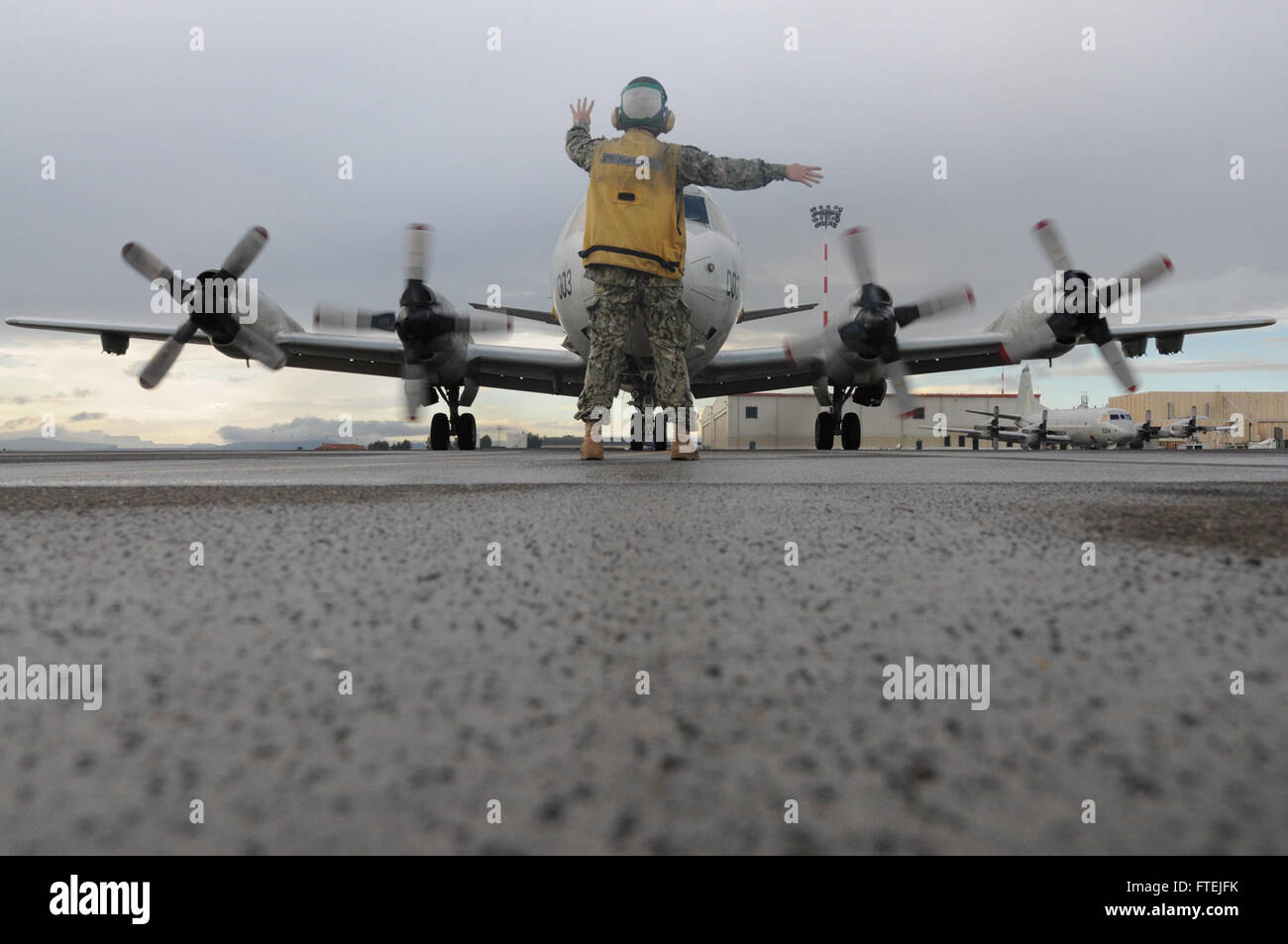 SIGONELLA, Sizilien (3. Dezember 2014) Luftfahrt Elektroniker / 2. Klasse Spencer Bean signalisiert eine P - 3 C Orion Seefernaufklärer gehörenden Patrol Squadron (VP) 4, 3. Dezember 2014. VP 4 führt Marinebetriebe in den USA 6. Flotte Bereich der Maßnahmen zur Erhöhung der Sicherheit der Vereinigten Staaten in Europa interessiert. Stockfoto