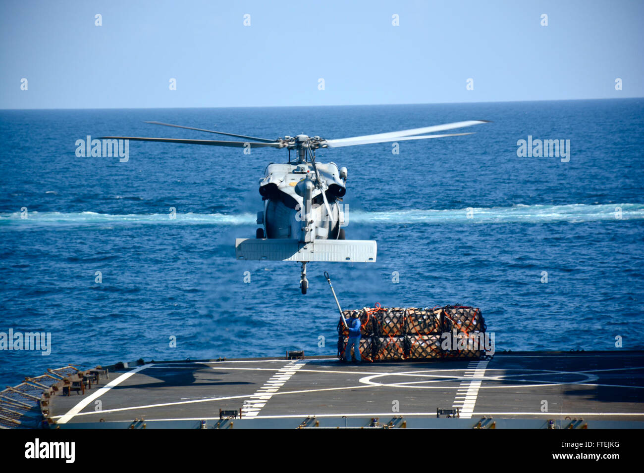 Am 17. Dezember 2014 führt ein MH-60S Seahawk Helikopter der Helicopter Sea Combat Squadron 23 Wildcards eine vertikale Auffüllung zwischen der USNS Patuxent (T-AO 201) und der USS Makin Island (LHD 8) im Golf von Aden durch, um die nationalen Sicherheitsinteressen der USA in Europa und Afrika zu unterstützen. Stockfoto