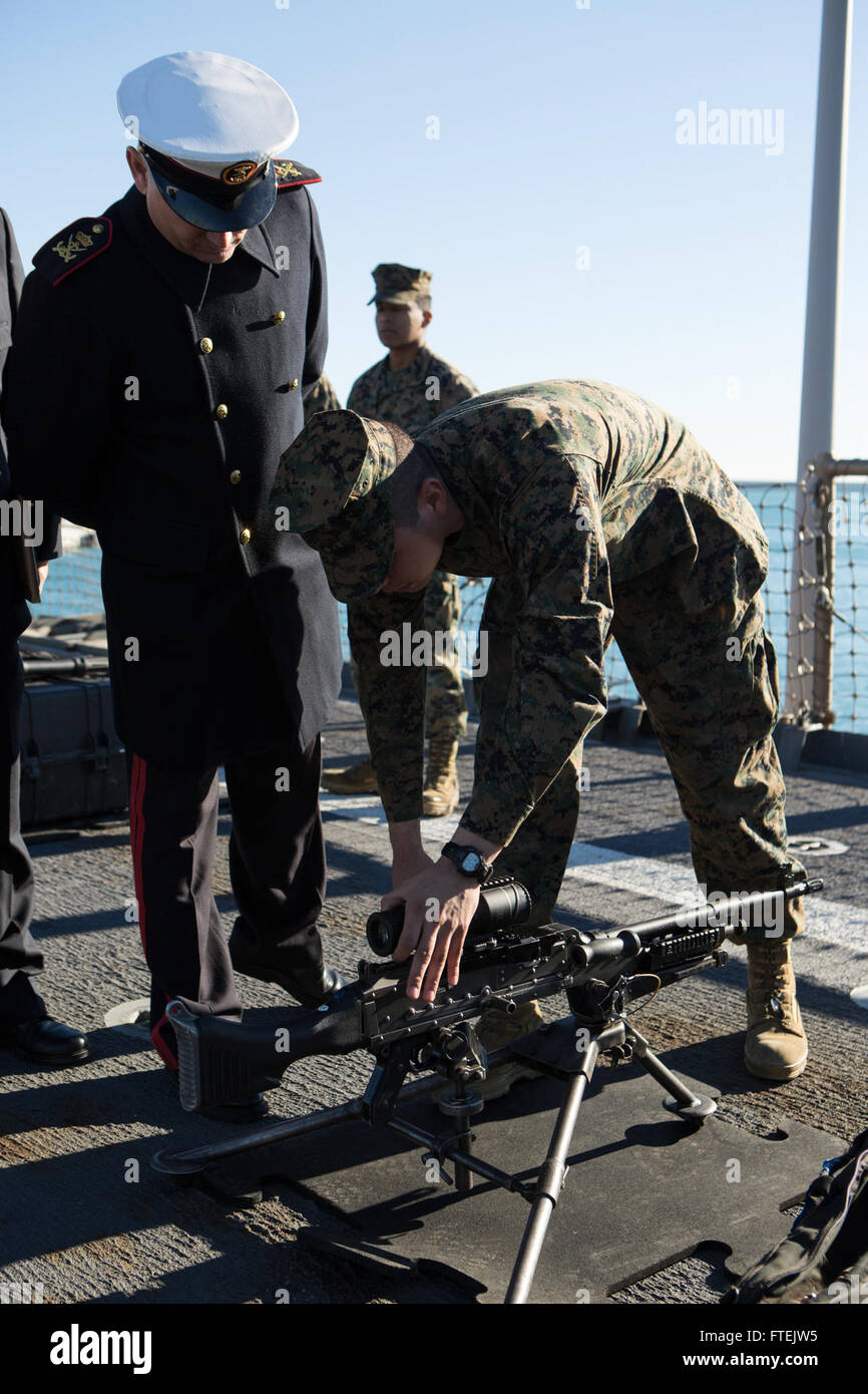 Ein U.S. Marine mit Battalion Landing Team 3rd Battalion, 6th Marine Regiment, 24th Marine Expeditionary Unit demonstriert einem spanischen Militärbeamten an Bord der USS Fort McHenry (LSD 43) in Valencia, Spanien, während eines Hafenbesuchs am 31. Dezember 2014 ein Maschinengewehr M240B. Stockfoto