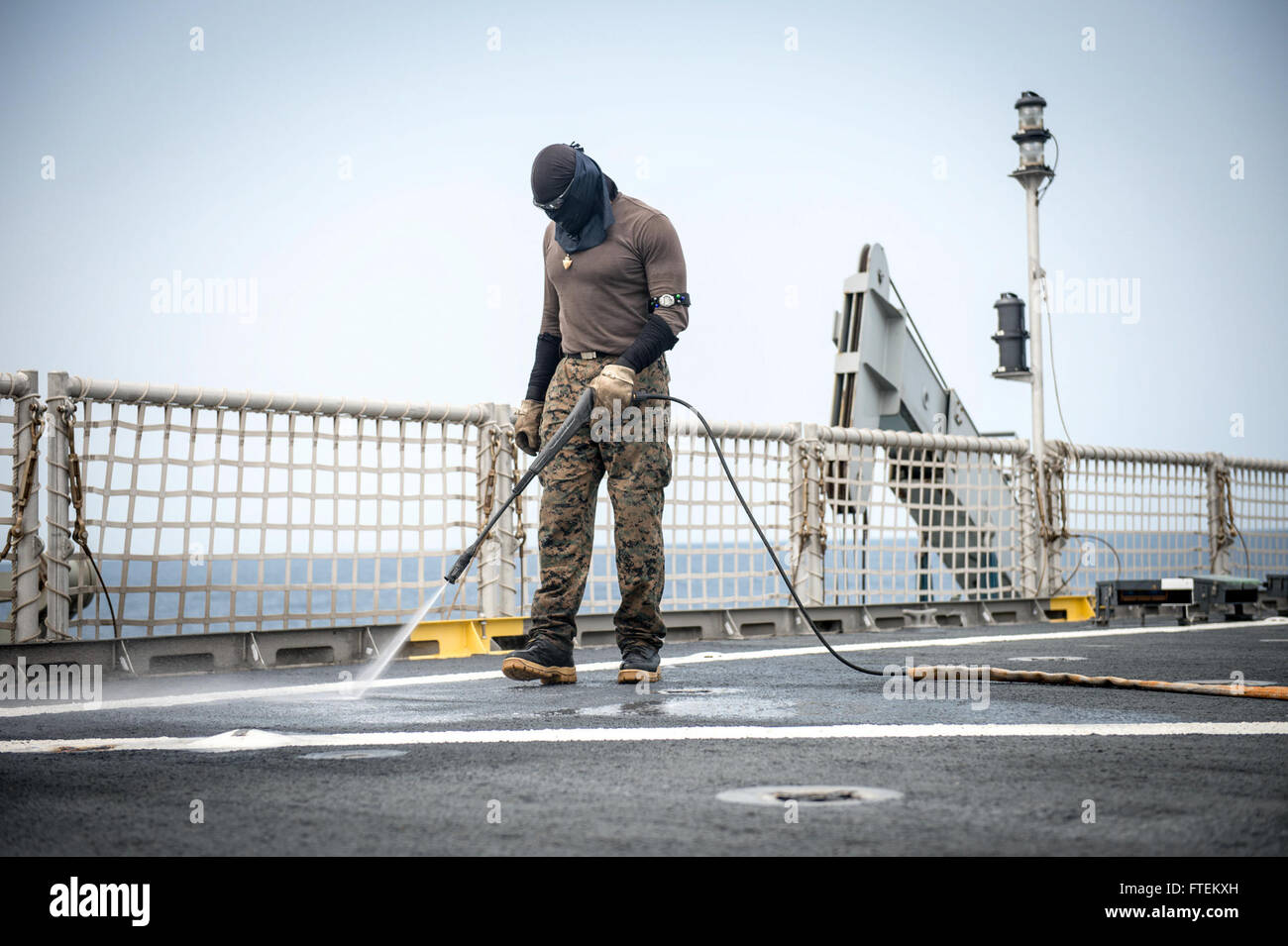 Seaman Joe Lyons reinigt das Flugdeck der USNS Spearhead, einem gemeinsamen Hochgeschwindigkeitsschiff, während eines geplanten Einsatzes zur Unterstützung der Africa Partnership Station. Das Schiff ist Teil internationaler Bemühungen zum Kapazitätsaufbau, um die Sicherheit im Seeverkehr im Gebiet der 6. US-Flotte zu verbessern. Stockfoto