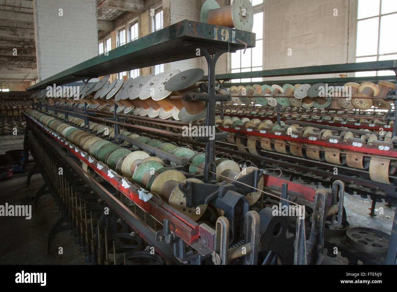 Racks von leeren Thread Spulen im Inneren drehen der Jahrhundert Seide Fabrik zu werfen. Stockfoto