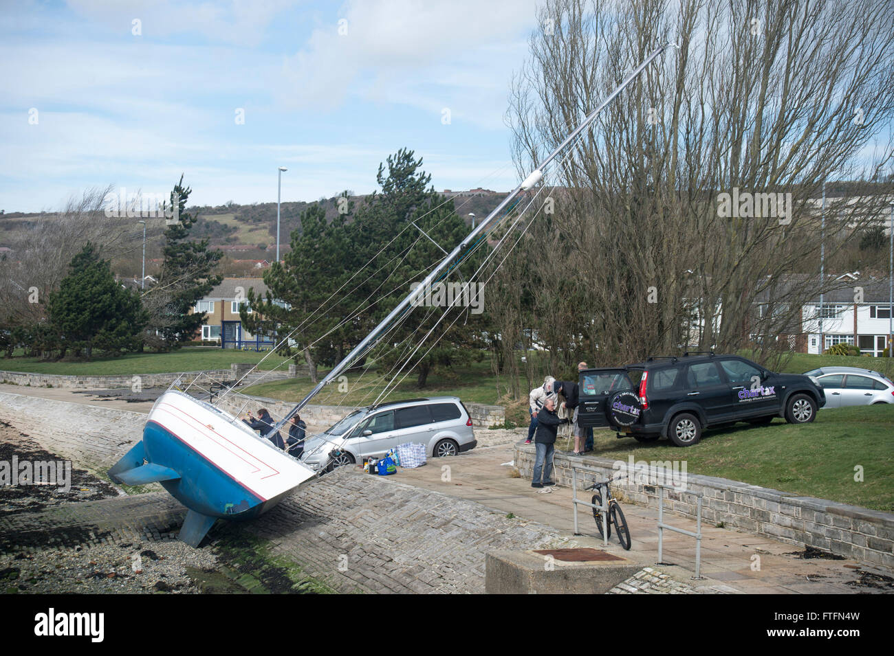 Hafen von Portsmouth, Hampshire, UK. 28. März 2016. Die Yacht "Faolan" liegt fast auf ihrer Seite am Ufer nach gefegt aus ihrem Anchorgae während Sturm Katie am Ostermontag. Bildnachweis: Rob Wilkinson/Alamy Live-Nachrichten Stockfoto