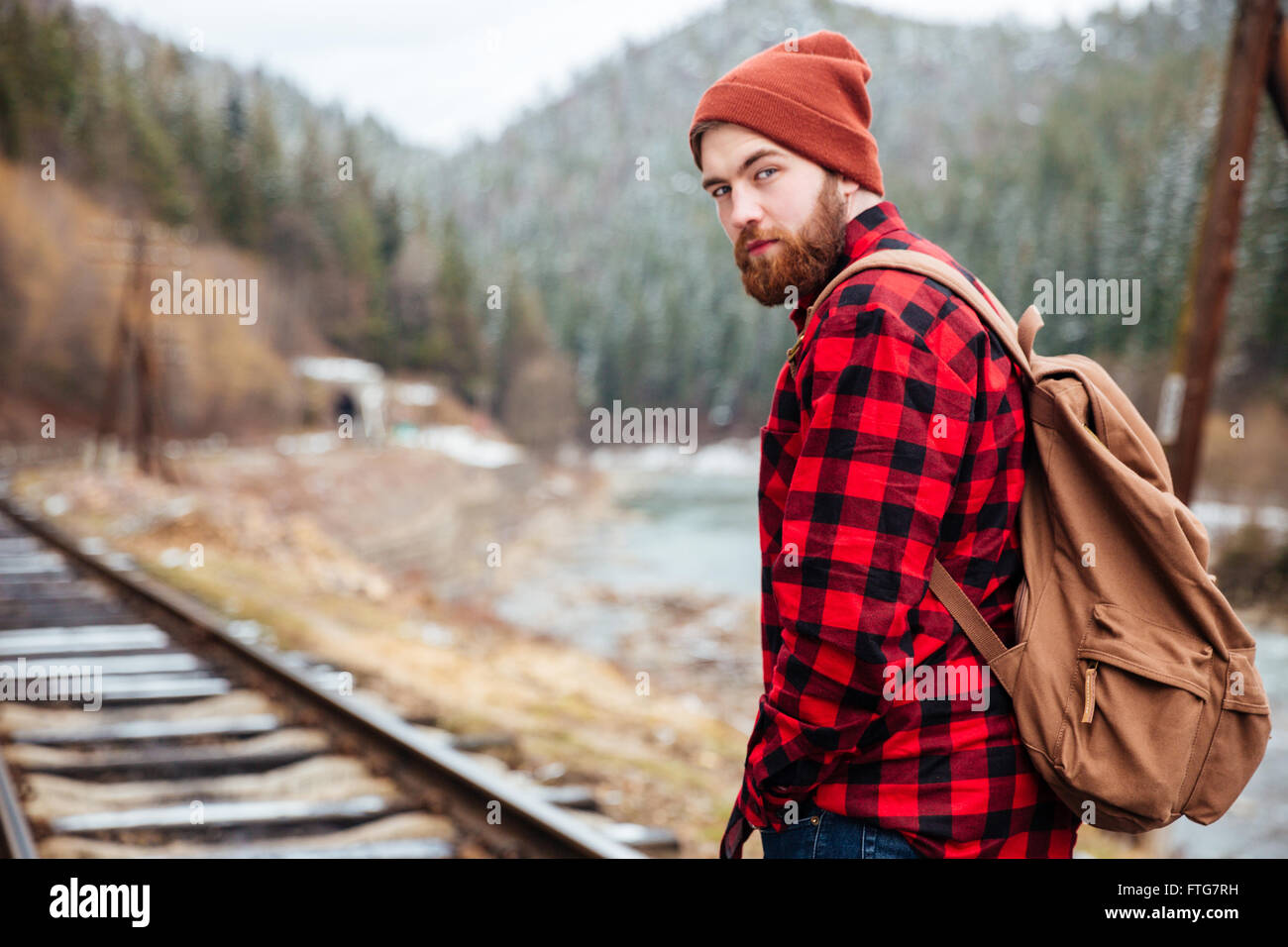 Hübscher bärtiger junger Mann im karierten Hemd Eisenbahn unterwegs in Bergen Stockfoto