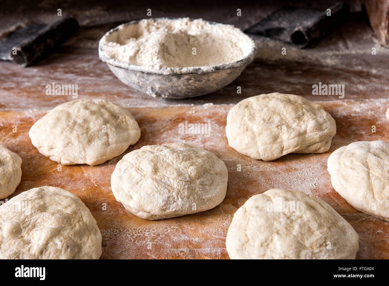Stillleben mit einzelnen Raw Brot ruht auf rustikalen Holz Mehl hautnah Stockfoto