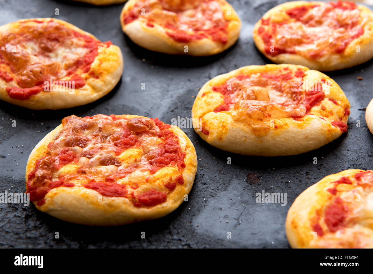 Stillleben mit frisch gebackenen Pizza Brötchen bedeckt in Tomatensauce und Käse überbacken Kühlung an heißen Pfanne frisch aus dem Ofen ich hautnah Stockfoto
