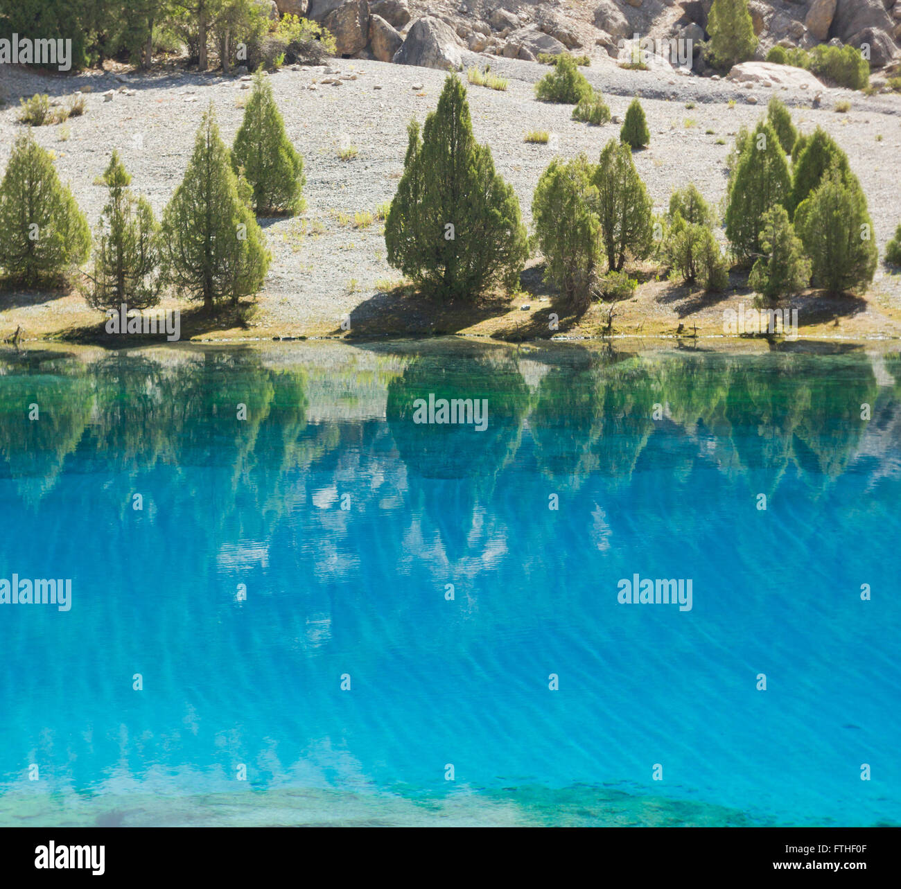 tiefblaue See reflektiert Grün der Bäume auf einer anderen bank Stockfoto