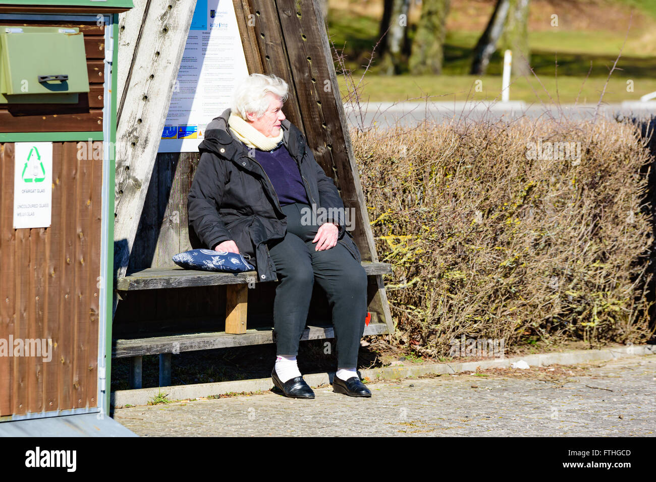 Ahus, Schweden - 20. März 2016: Eine ältere weibliche Person in einer Kabine Blick auf ihre Umgebung genießen die warmen Sprin sitzt Stockfoto