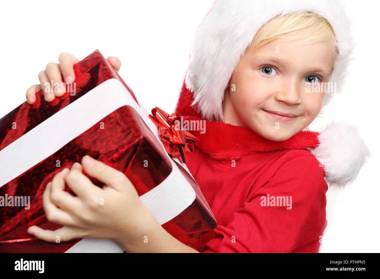 Weihnachten-Träume, magische Weihnachtszeit. Glückliches Kind in der Kappe des St. Nikolaus von verpackten Geschenk Stockfoto