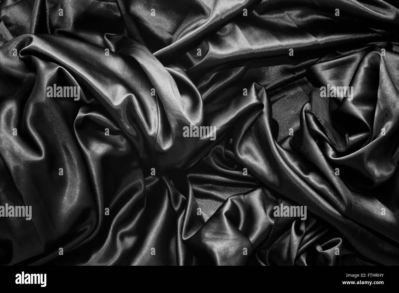 Textur von einer schwarzen satin Seide-Nahaufnahme Stockfoto