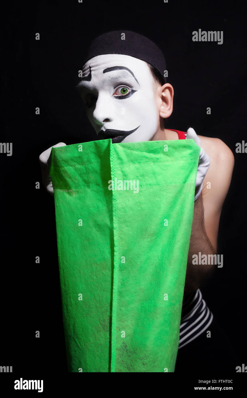 Porträt der Pantomime mit grüne Tasche auf schwarzem Hintergrund Stockfoto