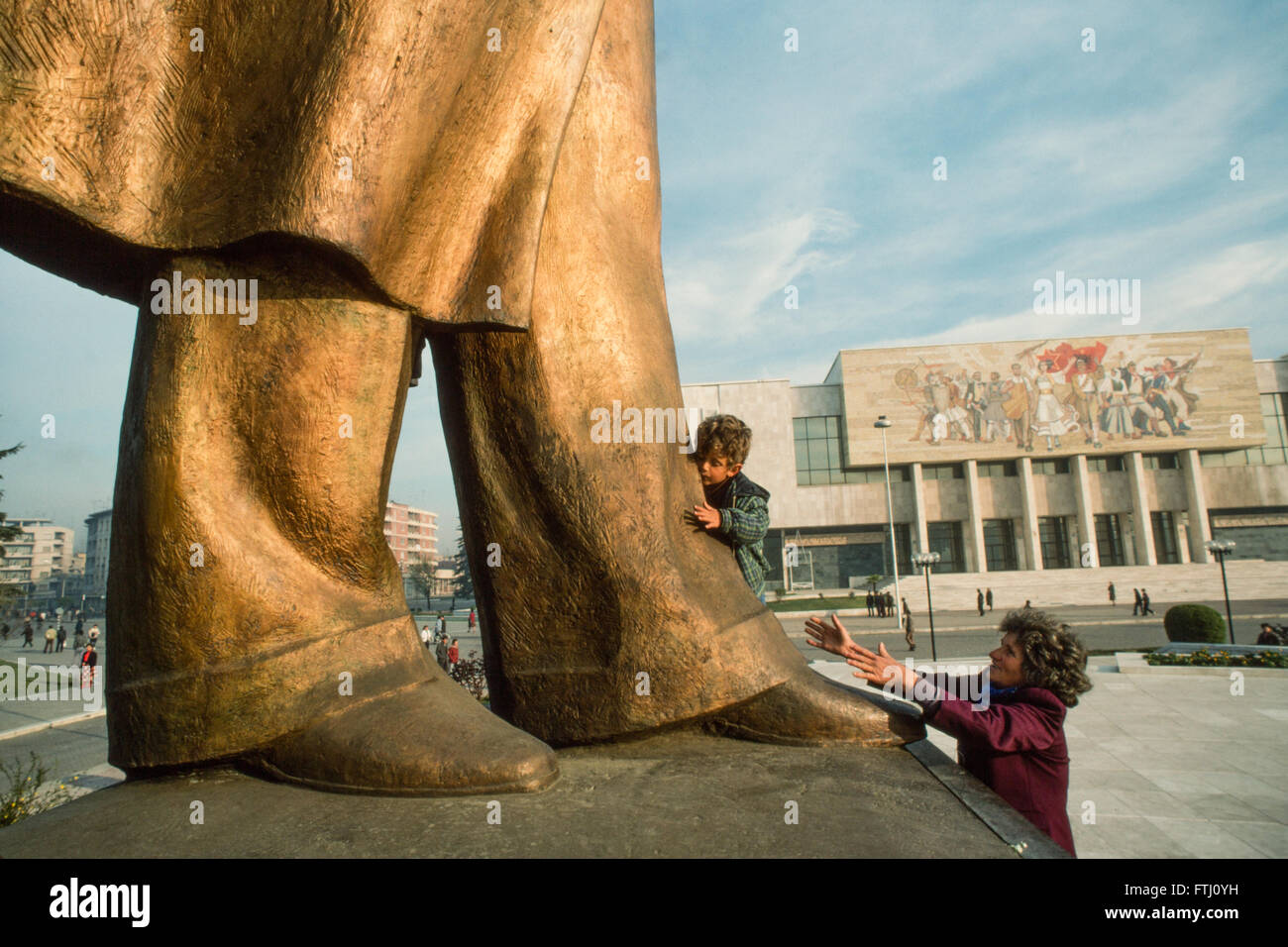 Kleiner Junge ermutigt von seiner Mutter, küssen die Füßen der Statue von Enver Hoxha, der Gründer des kommunistischen Staates, Tirana, 1990 Stockfoto