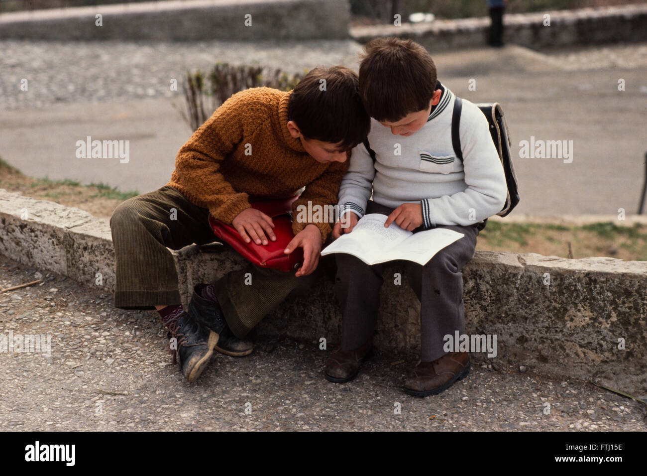 Zwei jungen weitertanzen ihre Hausaufgaben, sitzen auf einer Kebstone in Gjirokaster, Albanien Stockfoto