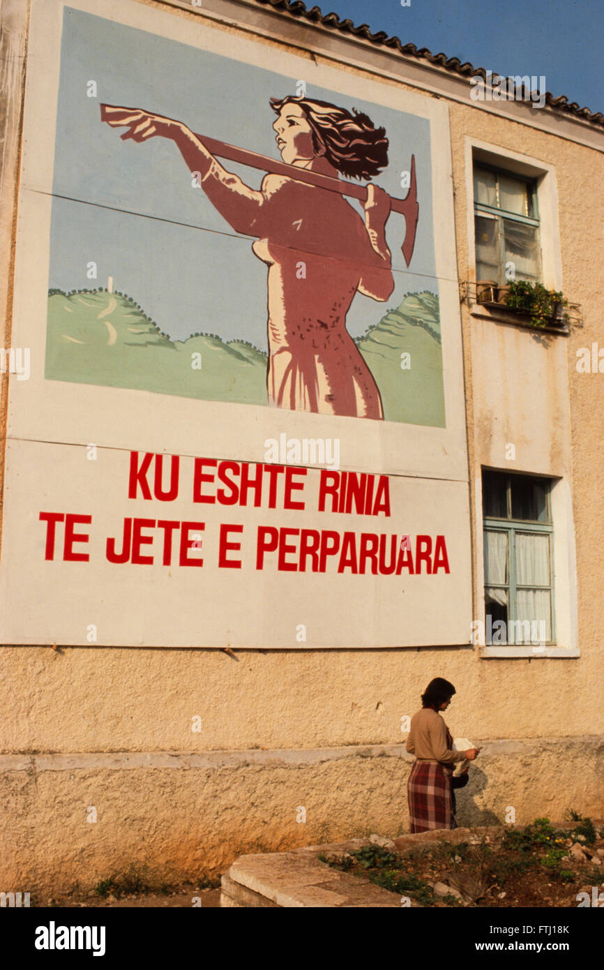 Eine Frau geht vorbei an einem Wandposter, die sagt "übernehmen die Verantwortung Erwachsenwerden", Saranda, Albanien. Stockfoto