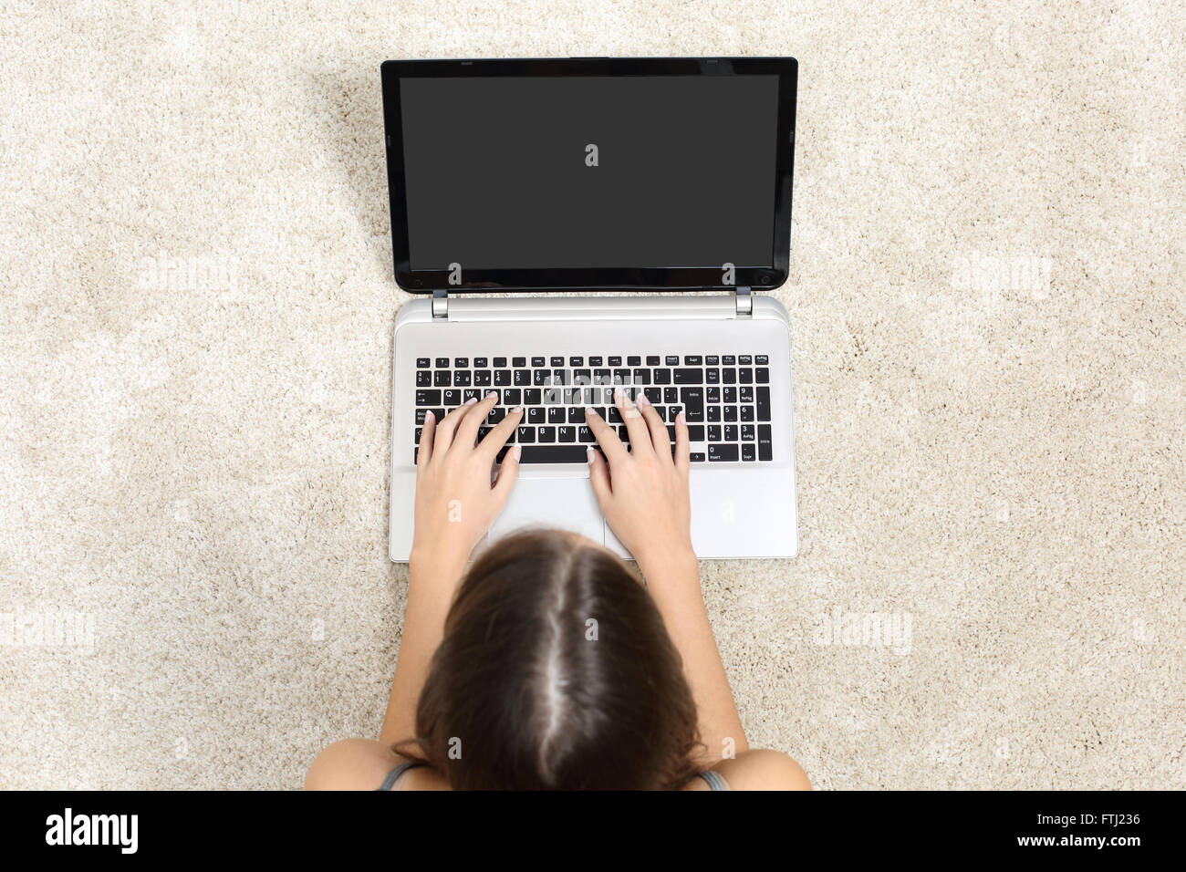 Draufsicht einer Frau mit Laptop arbeiten und leeren Bildschirm auf dem Boden zu Hause Stockfoto