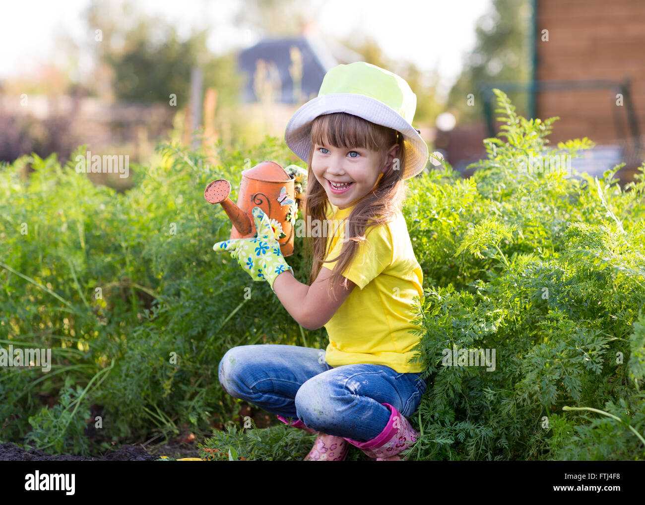 Kleines Mädchen posiert mit Gießkanne Stockfoto