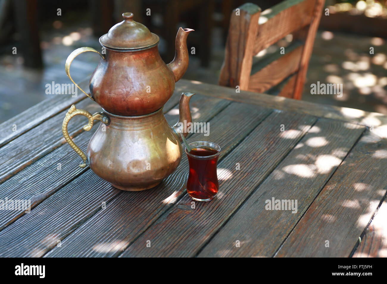 Traditionelle Kupfer türkische Teekanne in der Nähe von Glas auf Holztisch im café Stockfoto